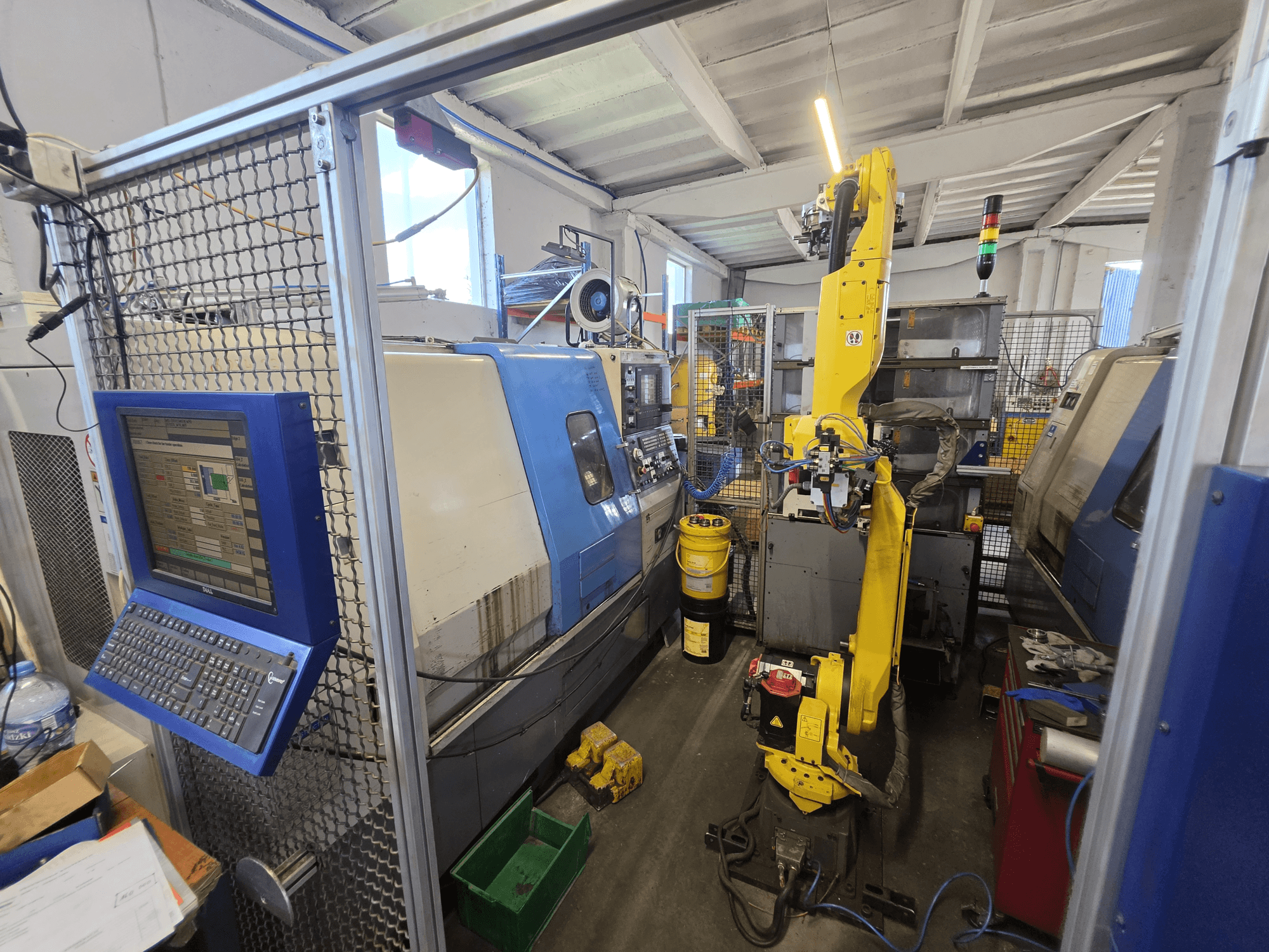 Tornio orizzontale Hyundai HIT-200C con robot FANUC M-20iA, vista frontale che mostra l'interfaccia di controllo e la configurazione della macchina.