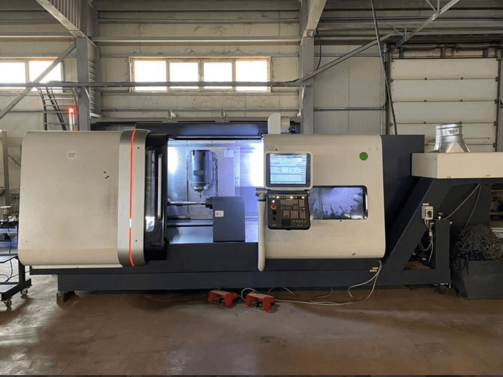 Centro di tornitura DMG MORI Beta 1250 TC, vista frontale con pannello di controllo, area di lavoro illuminata e utensili da taglio visibili.