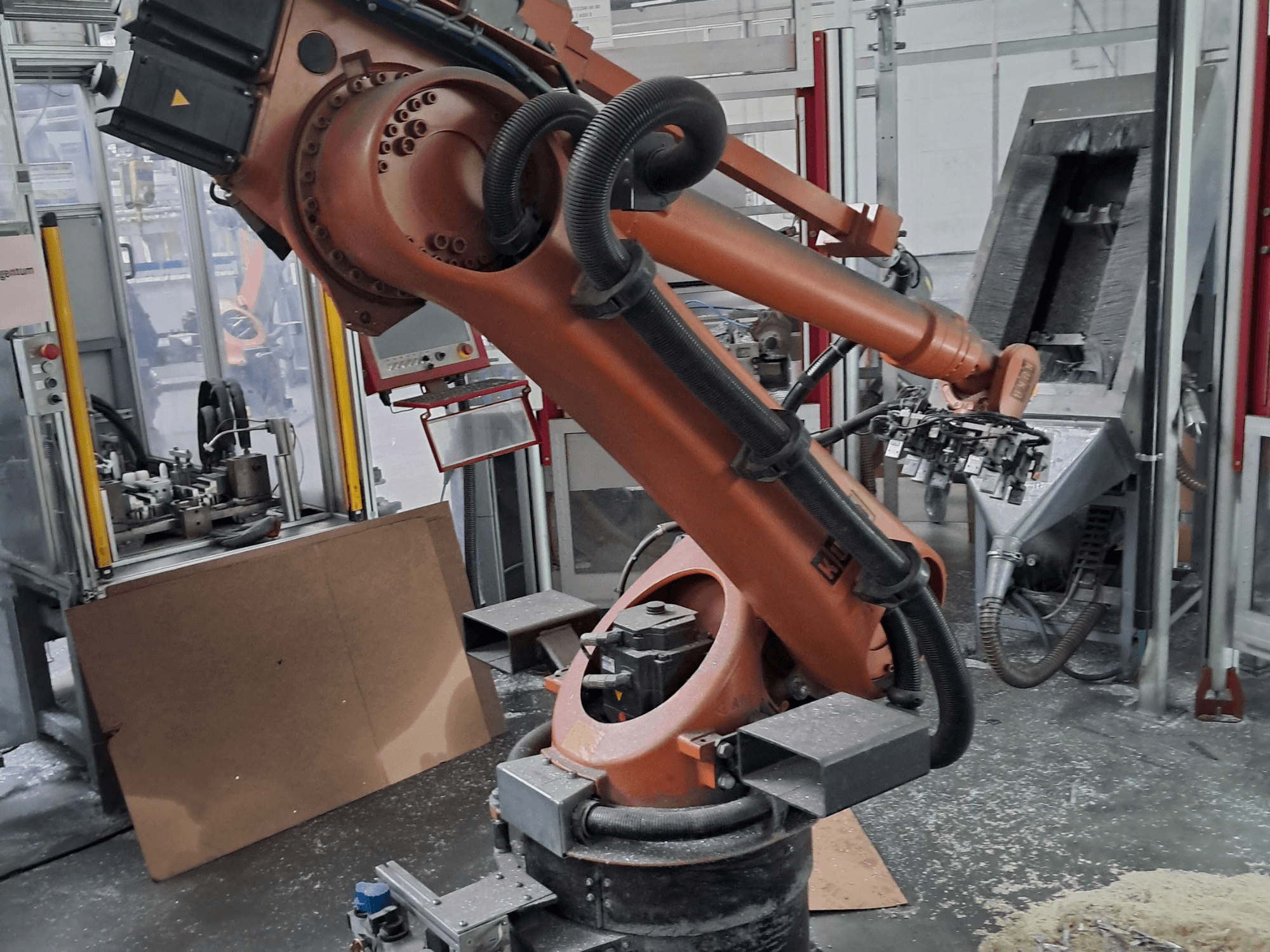 Braccio robotico KUKA KR 30 L 16-2 in un'officina, vista frontale. Presenta giunti articolati e, sullo sfondo, un ambiente di lavoro industriale.