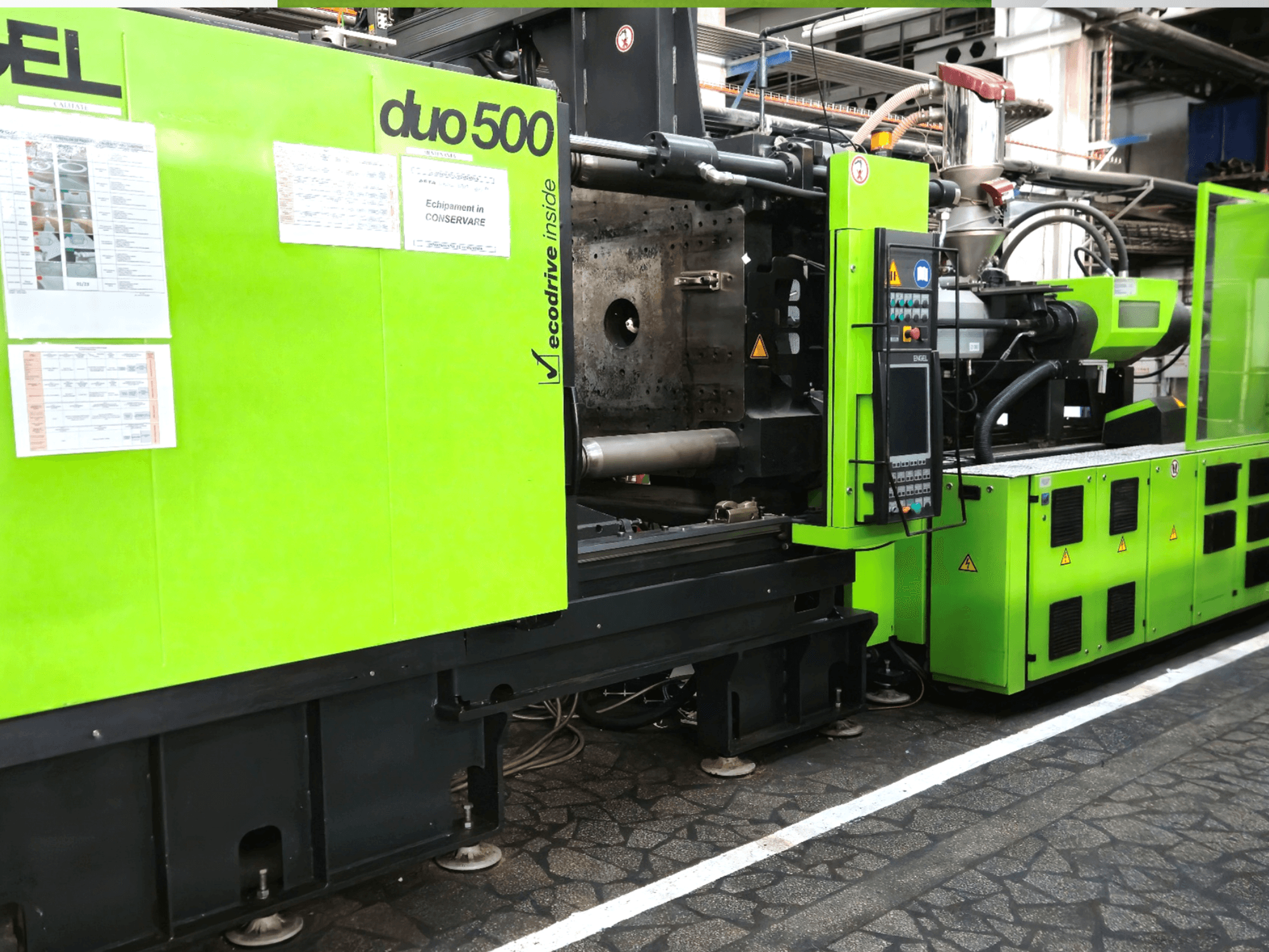 Macchina industriale verde Ergotron duo 500, vista frontale; con pannello di controllo, dettagli tecnici ed etichette di sicurezza dell'apparecchiatura.