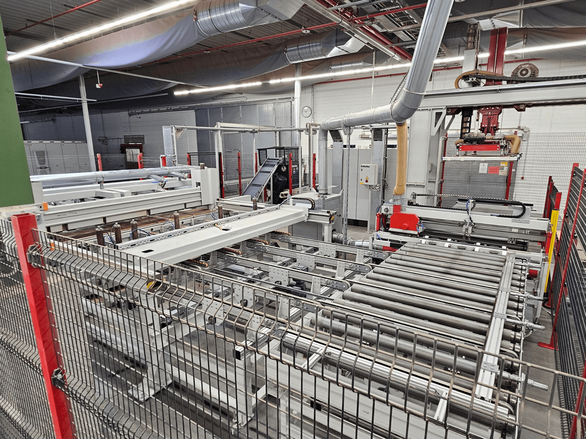 Sezionatrice HOLZMA HPP81-3200 in vista frontale, con rulli trasportatori e componenti del macchinario in un ambiente di officina.