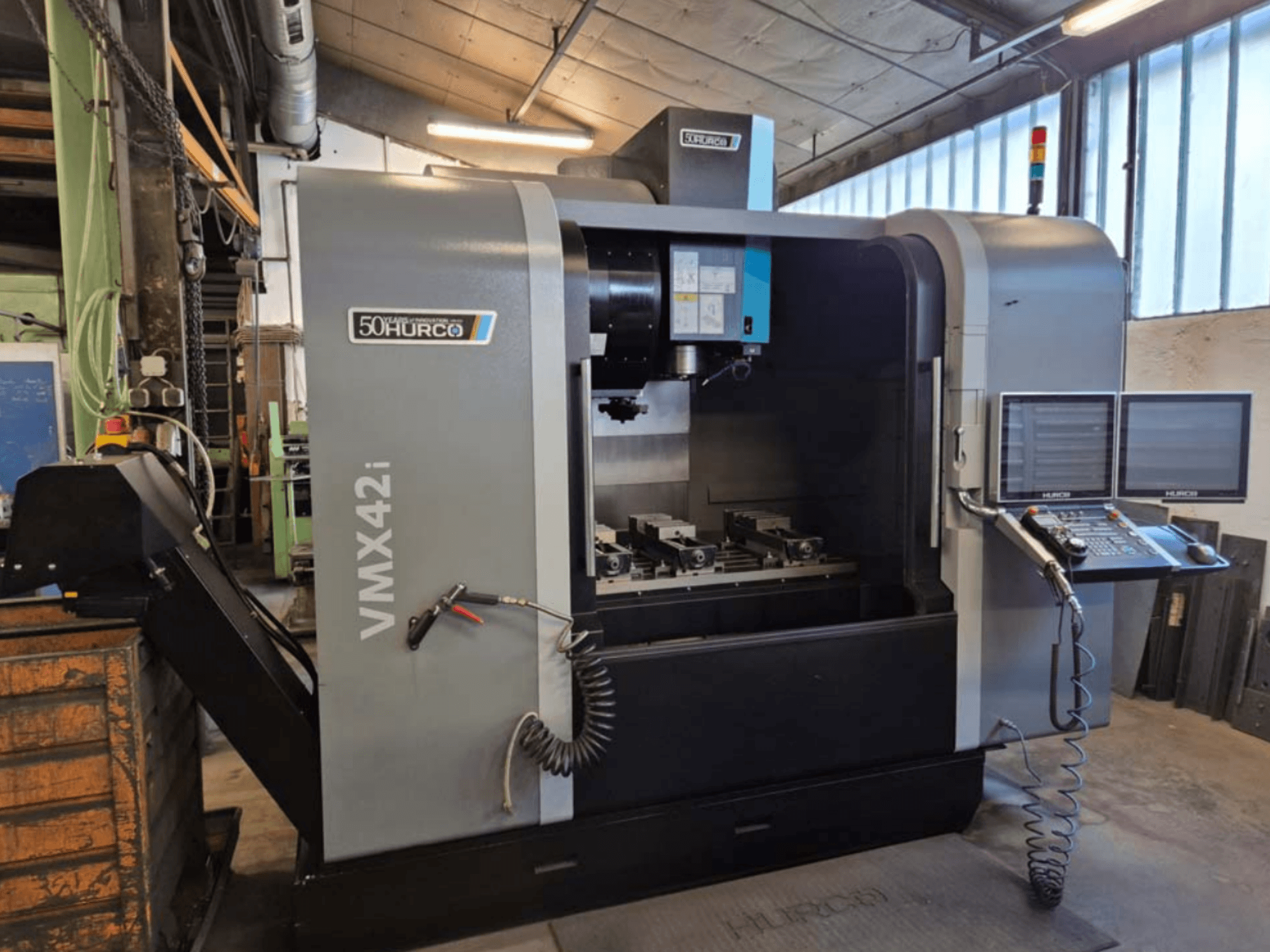 Centro di lavoro verticale Hurco VMX 42i, vista frontale, con pannello di controllo e area di lavoro con morse.