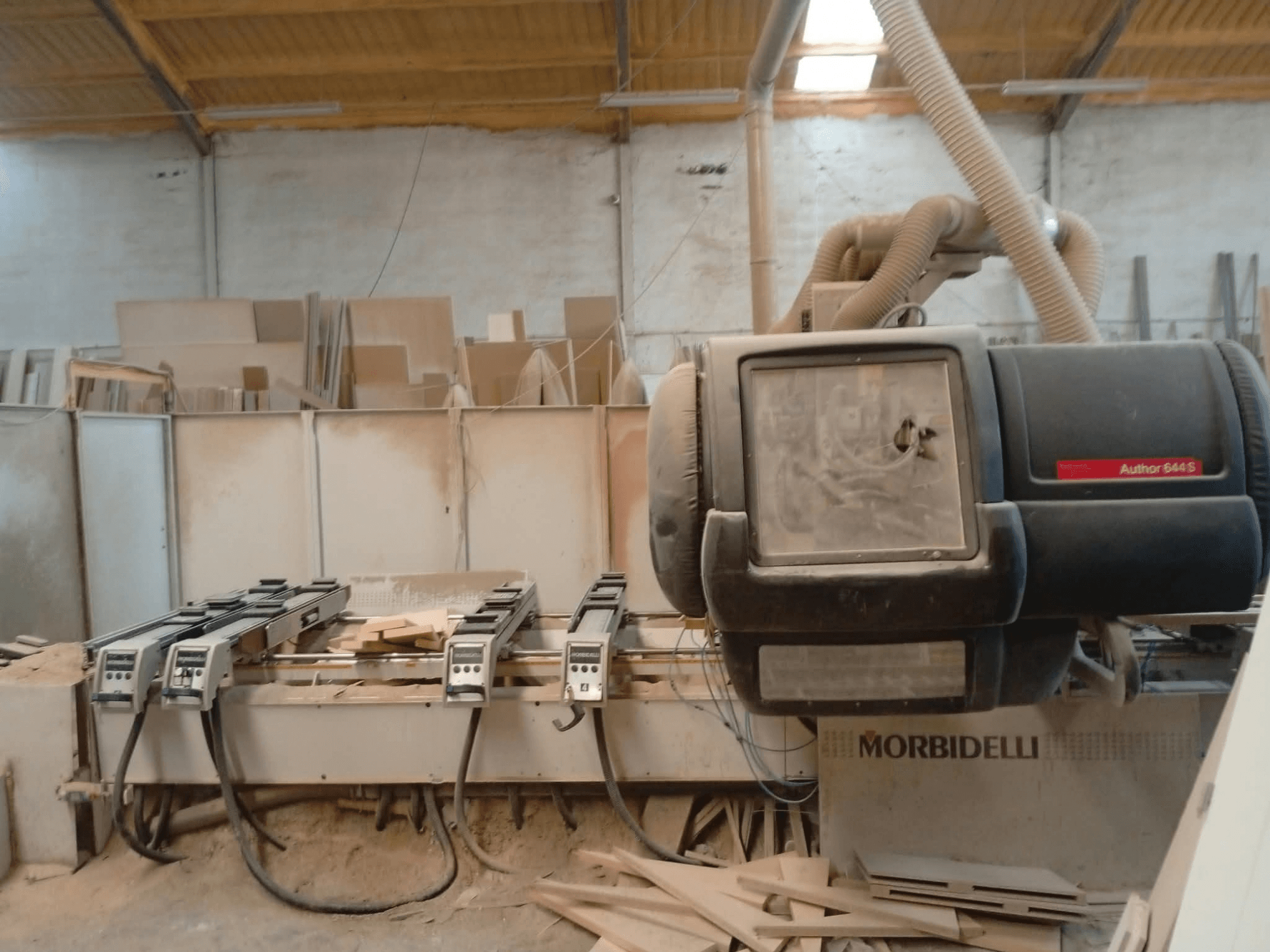 Centro di lavorazione CNC MORBIDELLI A644S FTP 41 PC esposto in un'officina, con vista frontale su cui sono visibili polvere e trucioli di legno.
