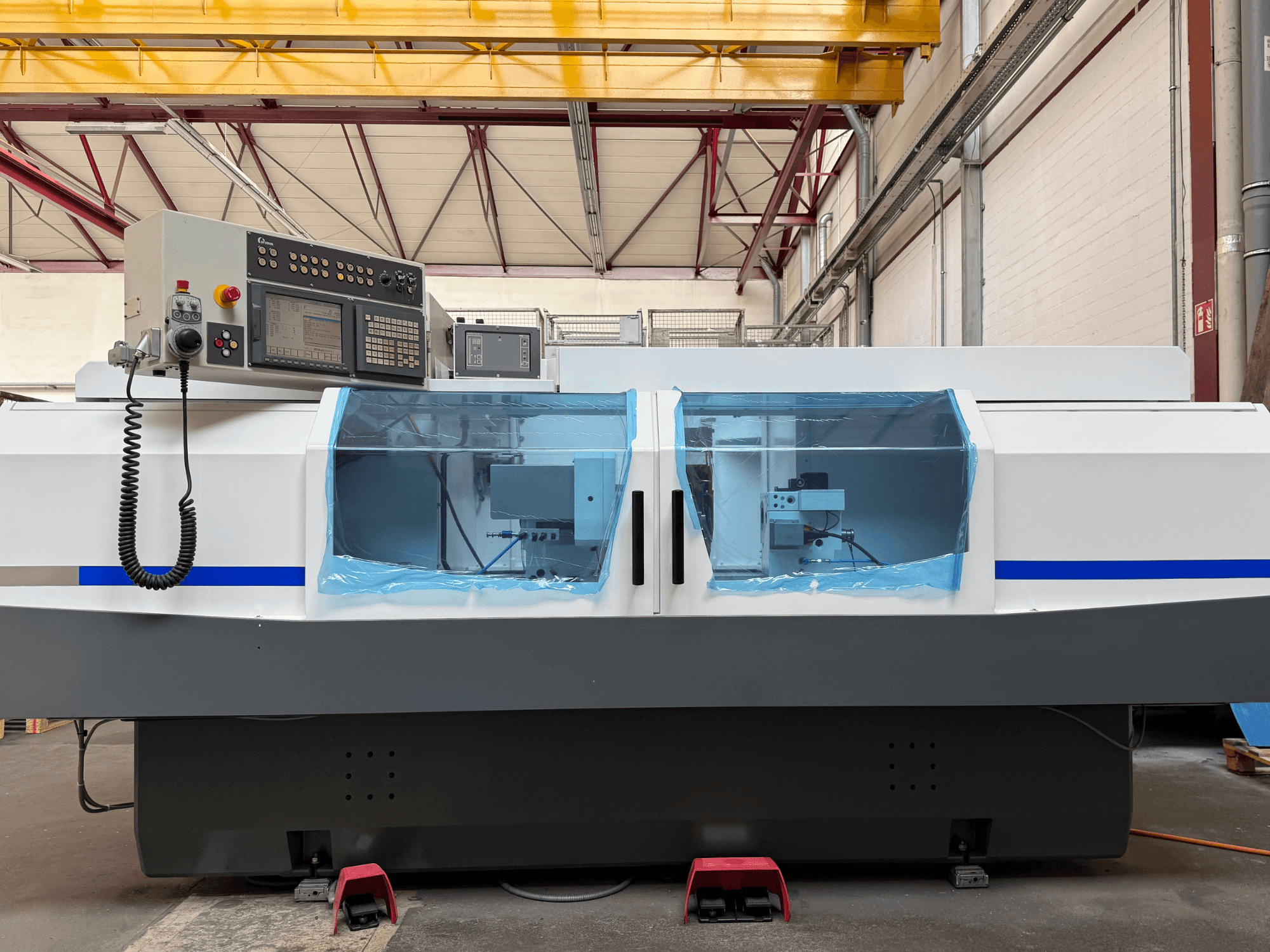 Rettificatrice cilindrica STUDER S33 CNC vista laterale, con pannello di controllo e coperture di sicurezza trasparenti.