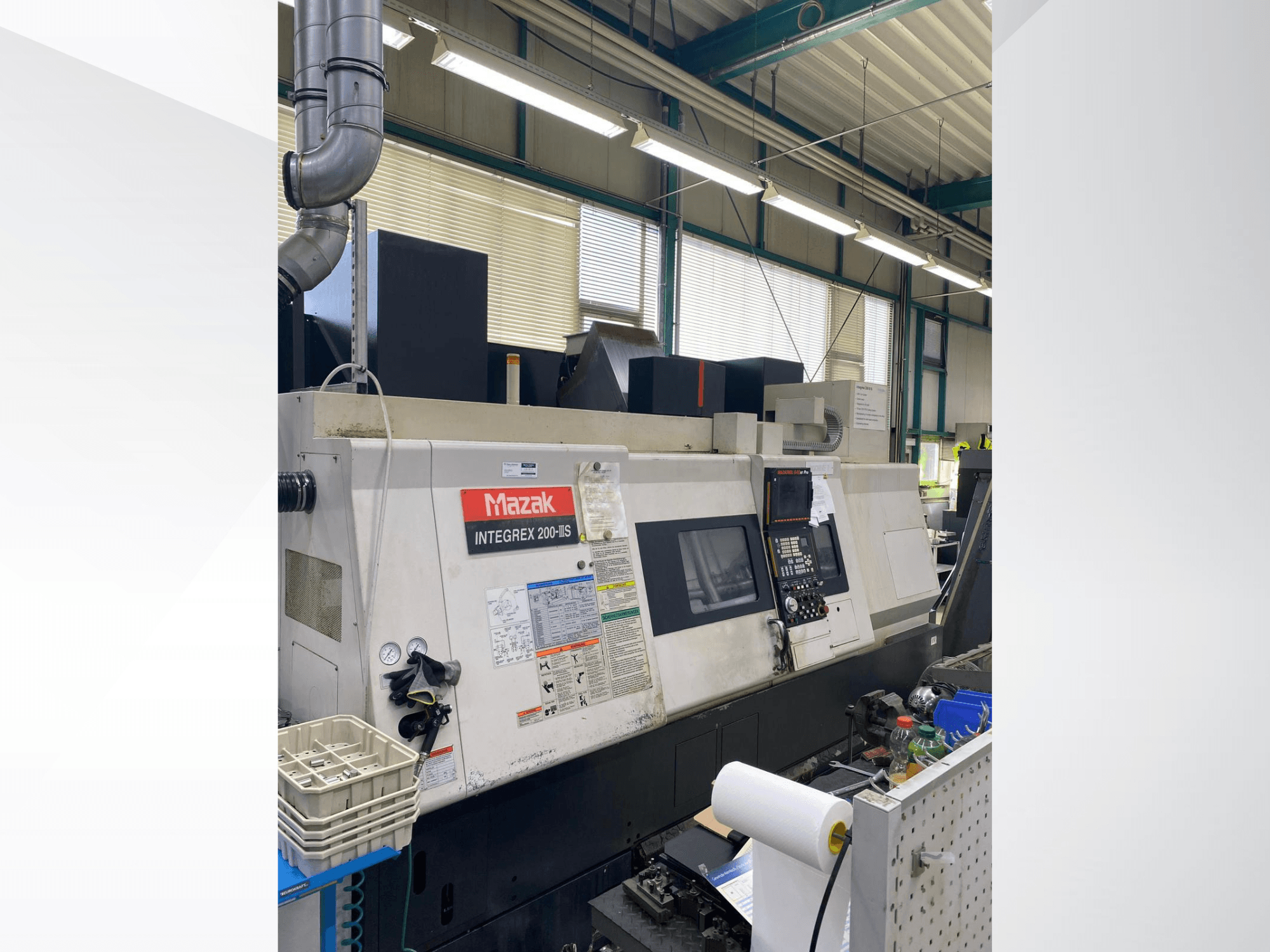 Centro di tornitura-fresatura Mazak INTEGREX 200 III S, vista laterale, che mostra il pannello di controllo, gli indicatori e gli utensili nell'area di lavoro.
