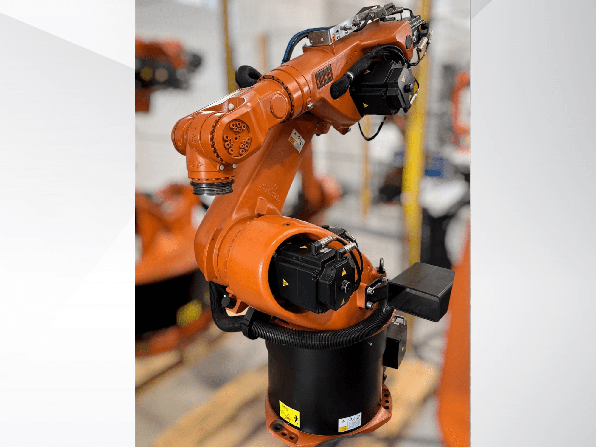 Braccio robotico KUKA KR 60-3 in arancione; vista laterale che mostra la base, i giunti e i moduli di controllo per le attività di automazione.