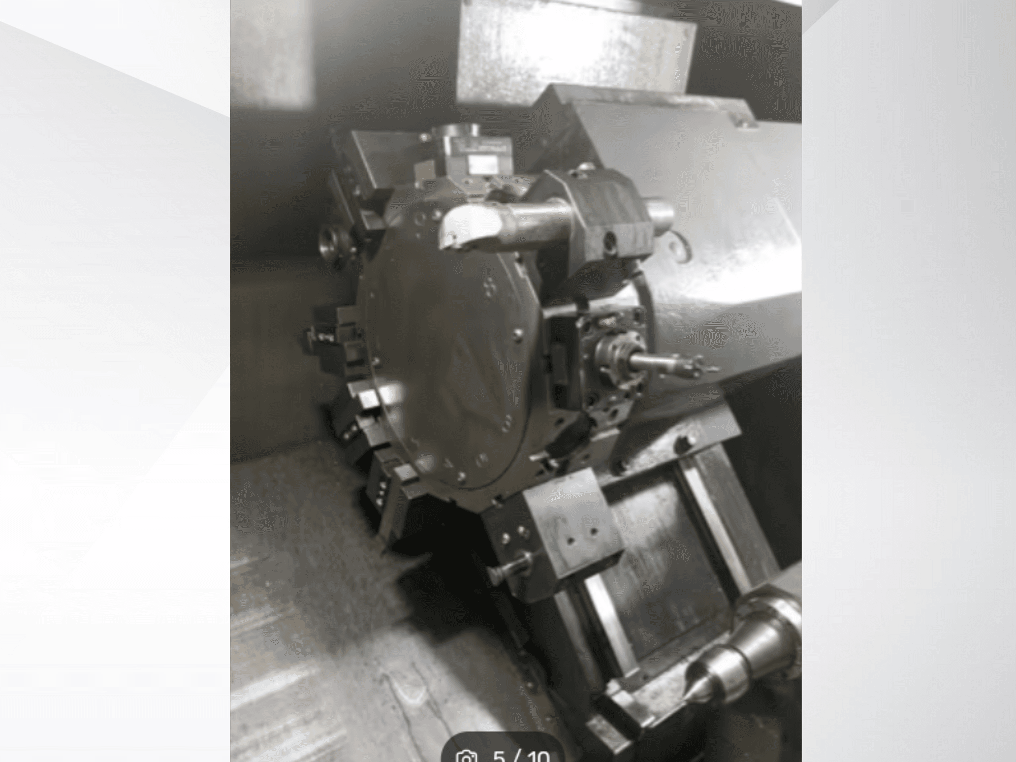 Primo piano di un pezzo di macchina di precisione, che mostra ingranaggi e componenti metallici, visto da una prospettiva angolata. Non è visibile il marchio.