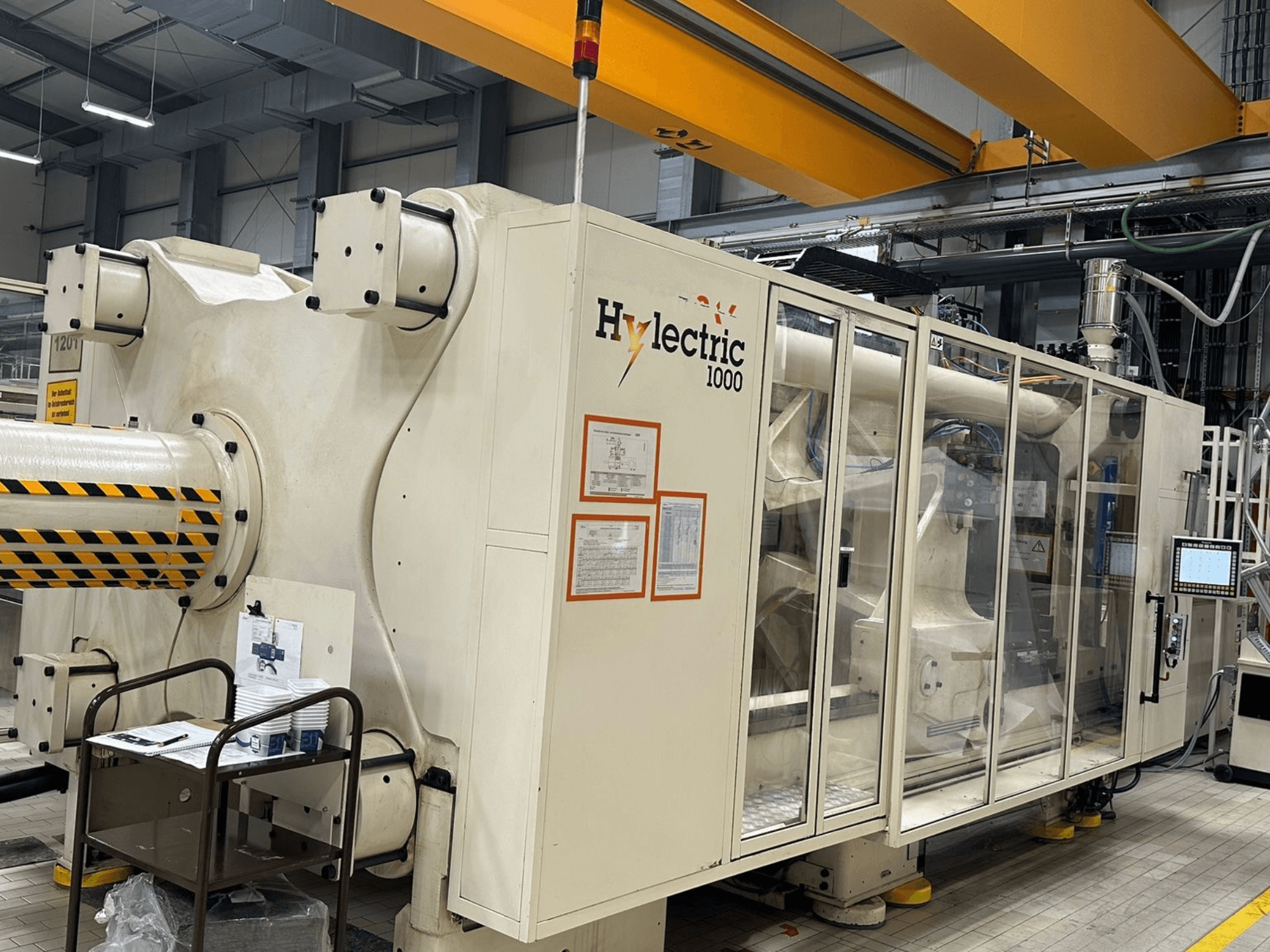 Macchina per lo stampaggio a iniezione elettrica Husky Hylelectric H1000 RS95/80, vista laterale con pannello di controllo e dispositivi di sicurezza visibili.