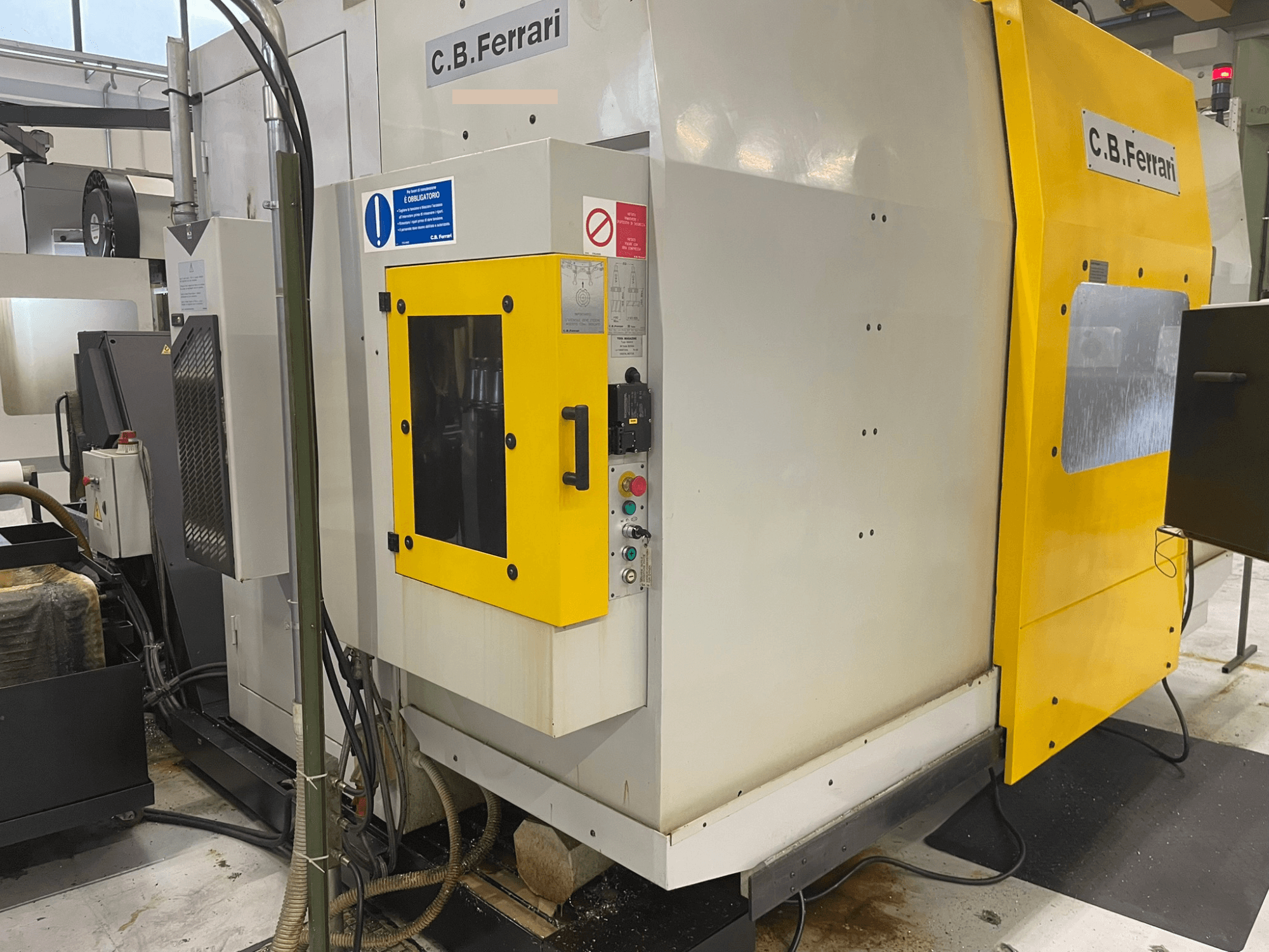 Macchina industriale C.B. Ferrari, vista frontale; presenta uno sportello giallo, un pannello di controllo e componenti di lavorazione visibili.