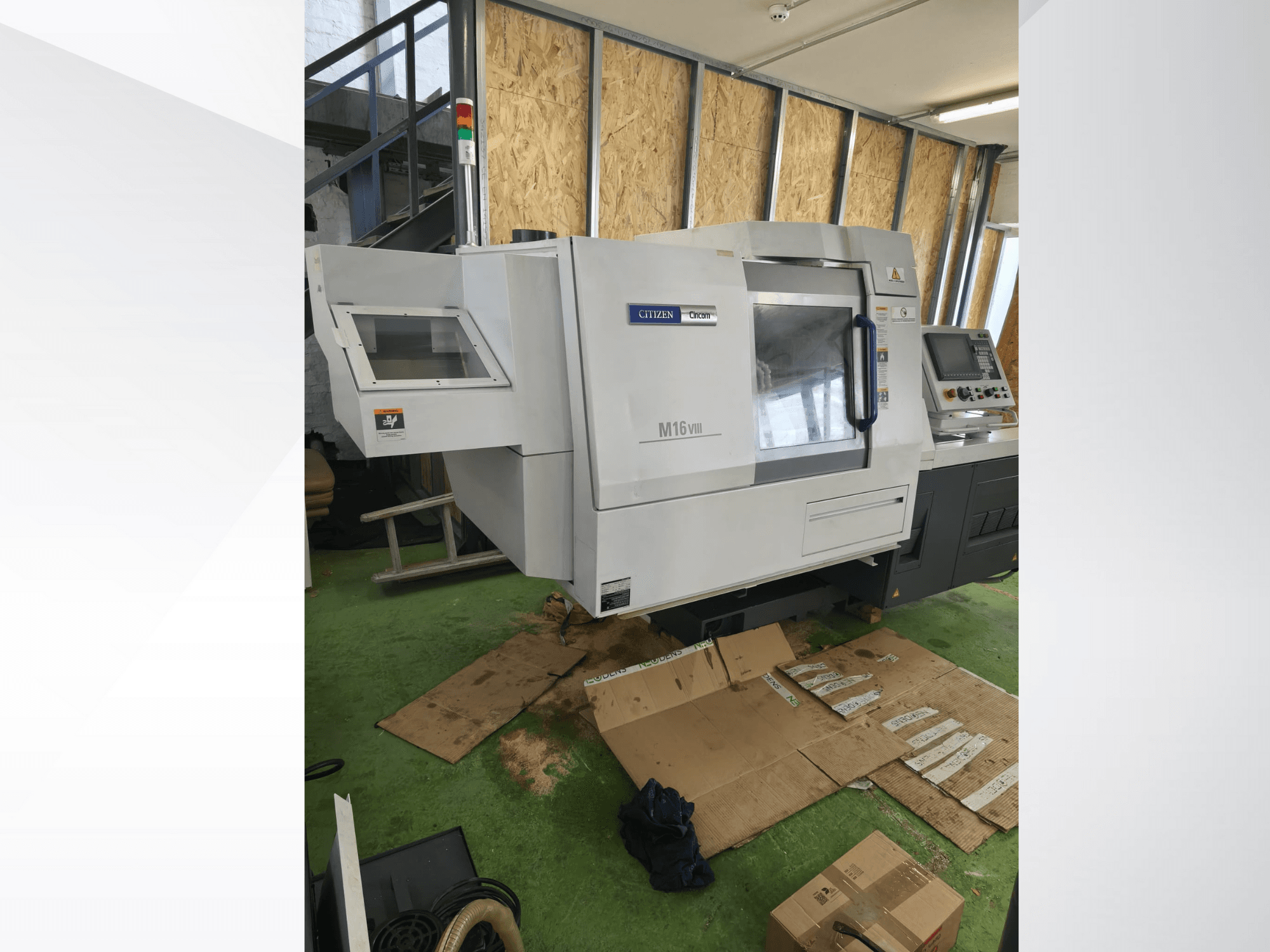 Tornio CNC Citizen M16VIII in vista frontale, con pannello di controllo e spie di sicurezza, posizionato su una pavimentazione verde.