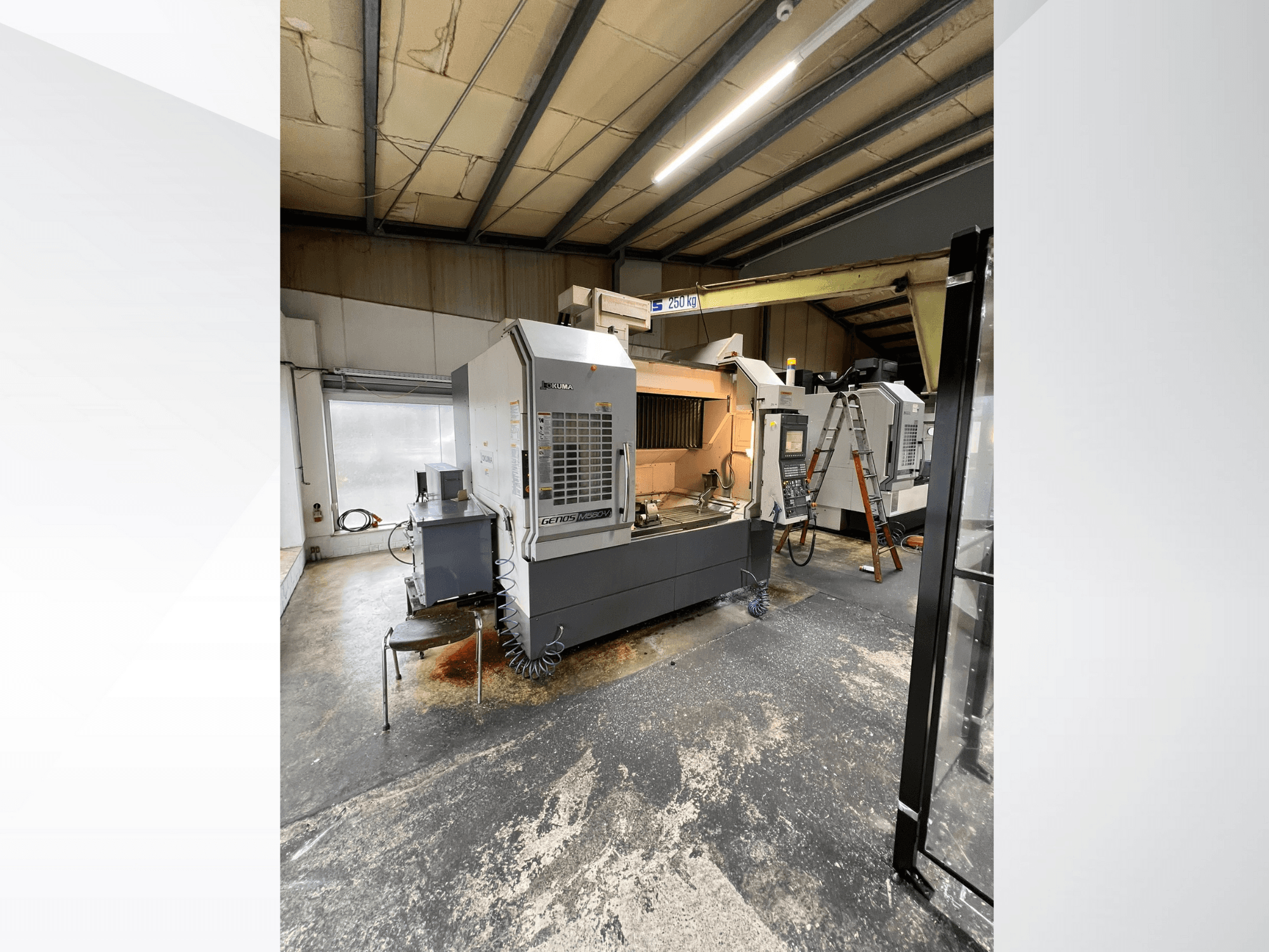 Macchina CNC GRETOS 750 in un'officina, vista frontale, che mostra il pannello di controllo e l'area di lavoro con gli utensili, sullo sfondo una scala visibile.