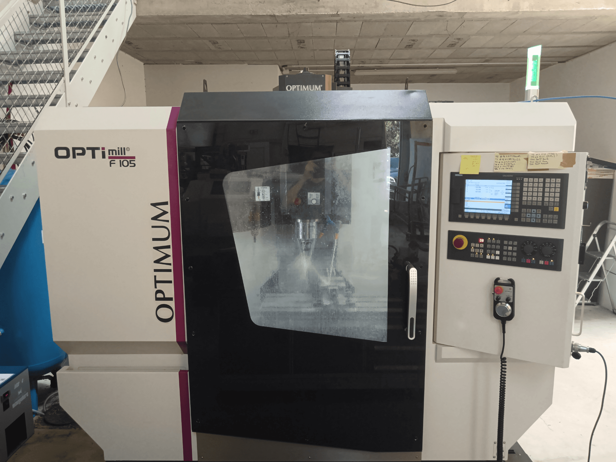 Vista frontale del centro di lavoro verticale Optimum Optimill F 105, con pannello di controllo e finestra di visualizzazione.