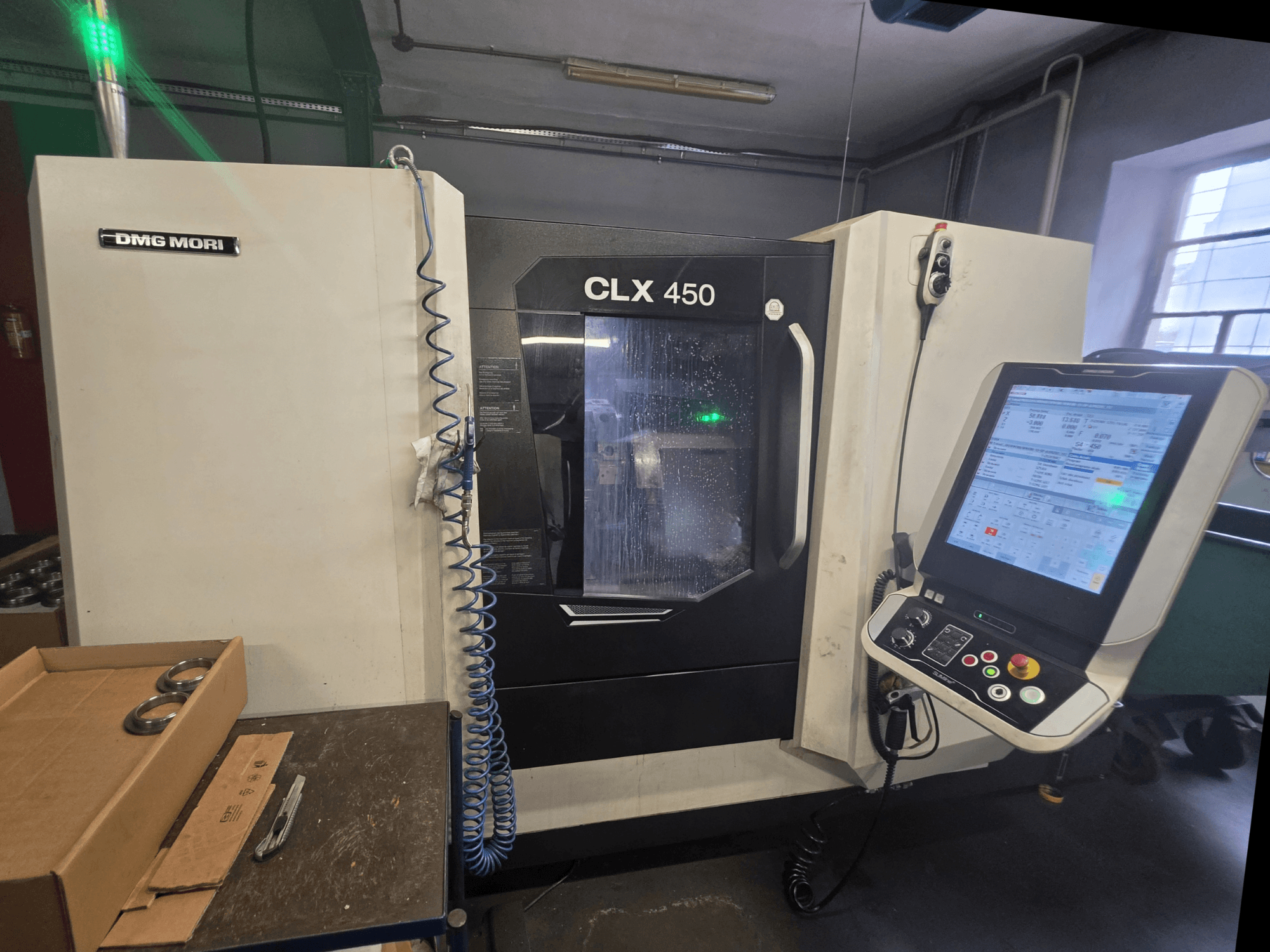 Vista frontale del tornio orizzontale DMG MORI CLX 450 V3 con pannello di controllo, sistema di lubrificazione e area di lavoro.