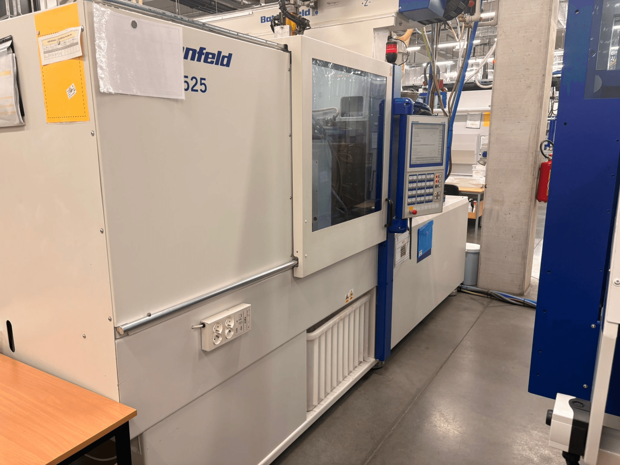 Macchine di Arburg, modello 620S, vista frontale che mostra il pannello di controllo e le porte di alimentazione in un ambiente di fabbrica.