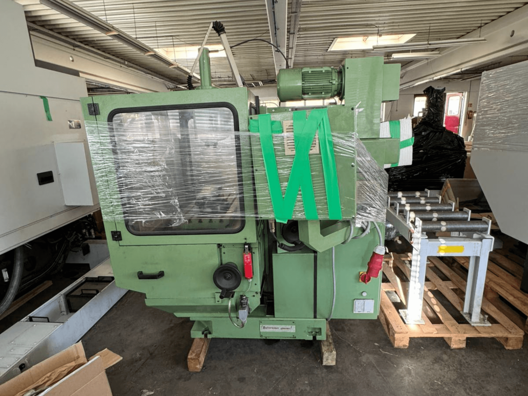 Centro di lavorazione verticale KUNZMANN WF 4/3 visto di fronte, avvolto in plastica, con corpo verde e comandi visibili.