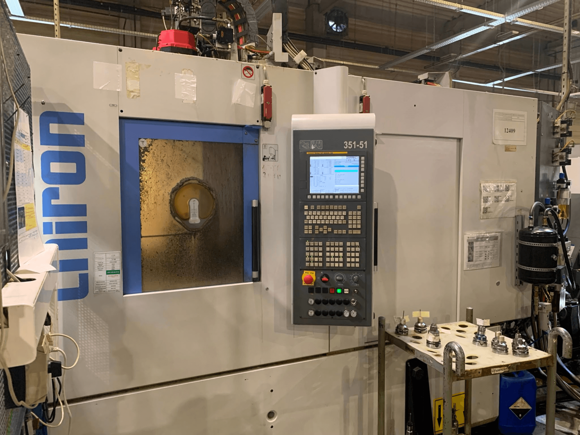 Centro di lavorazione verticale CHIRON DZ15W MAGNUM HS, vista frontale che mostra il pannello di controllo e l'area di lavorazione con gli utensili.