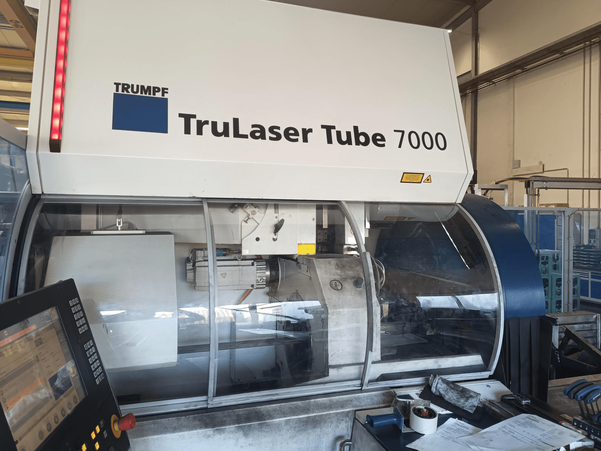TRUMPF TruLaser Tube 7000, vista frontale della macchina con pannello di controllo, che mostra le caratteristiche del taglio laser e l'area di lavoro.