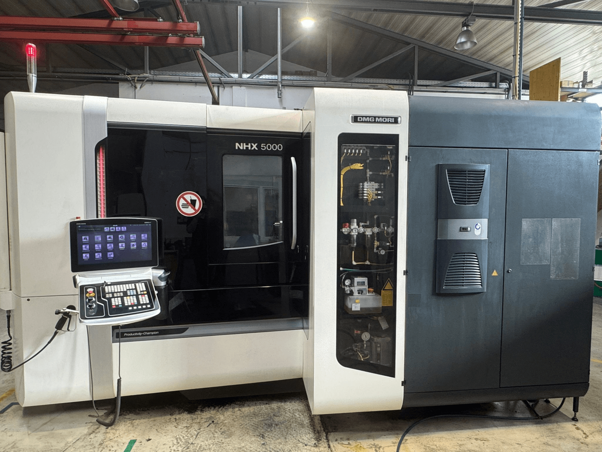 Vista frontale del centro di lavoro orizzontale DMG MORI NHX 5000, che mostra il pannello di controllo e i dettagli della macchina.