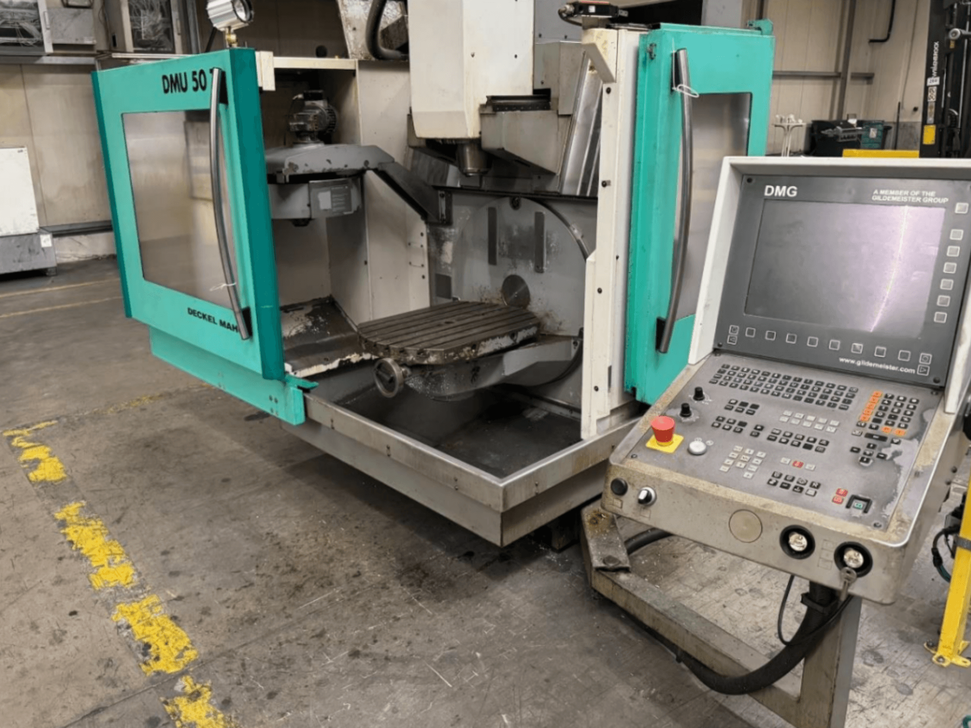 Fresatrice DMG DMU 50 con porte aperte che mostra l'interno e il pannello di controllo, visto dal davanti.