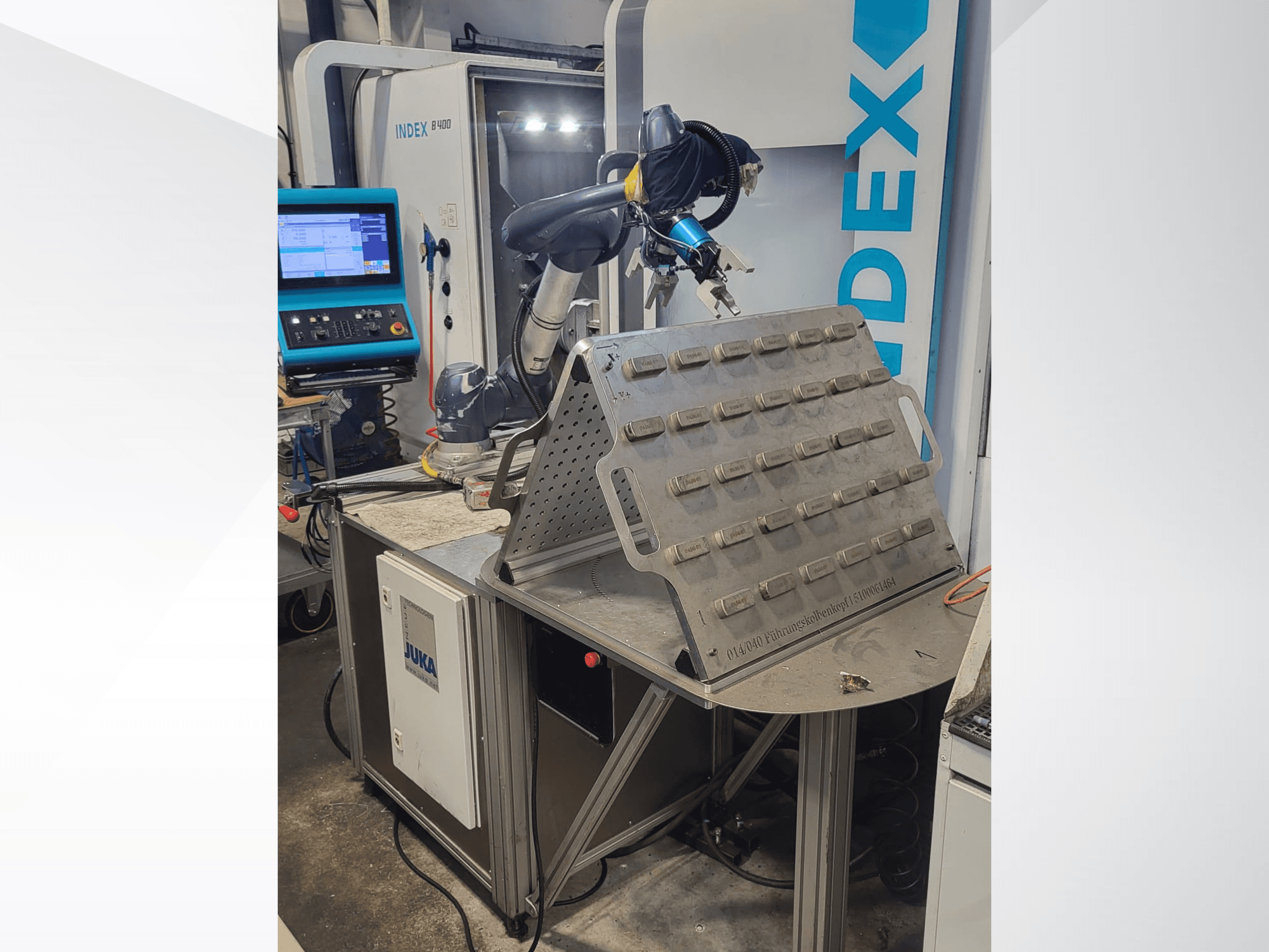 Robot collaborativo DOOSAN M1013 visto frontalmente, posizionato vicino a un tavolo di lavoro con portautensili e pannello di controllo.