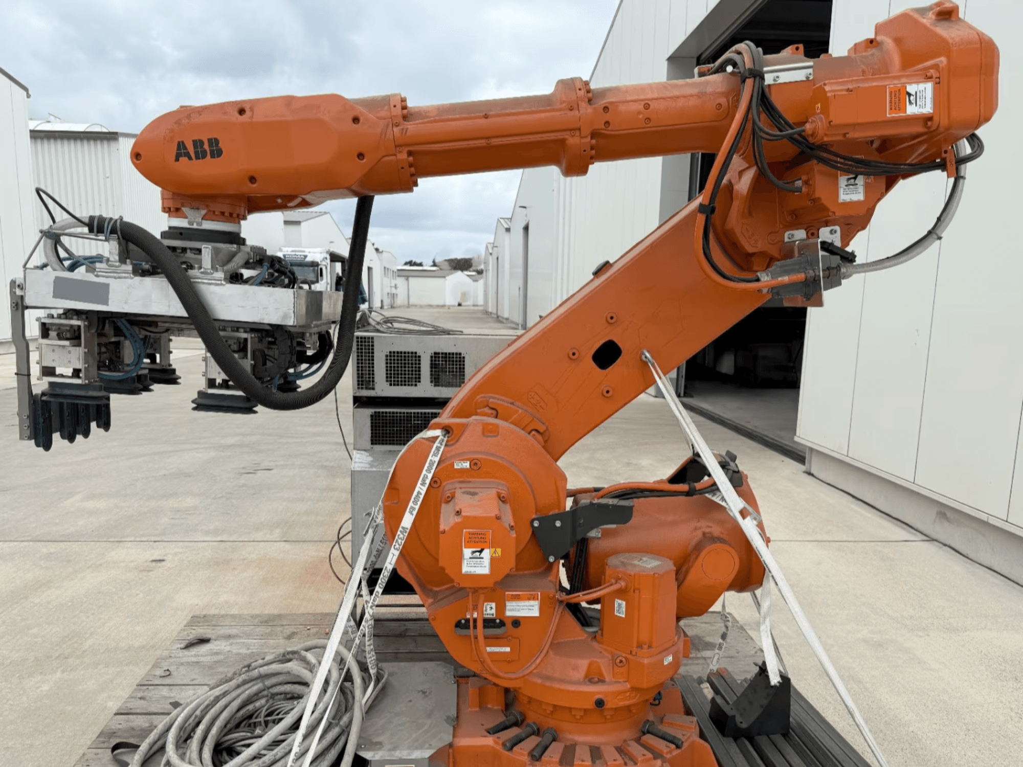 Braccio robotico ABB RB 6600-130/3.2 in vista laterale, con braccio robotico arancione con attacco a pinza e cablaggio visibile.