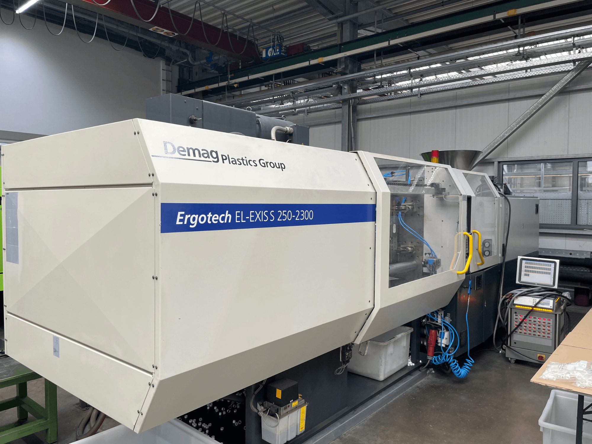 Macchina ad iniezione Demag Ergotech EL-EXIS S 250-2300, vista laterale, che mostra il pannello di controllo e il sistema di alimentazione.