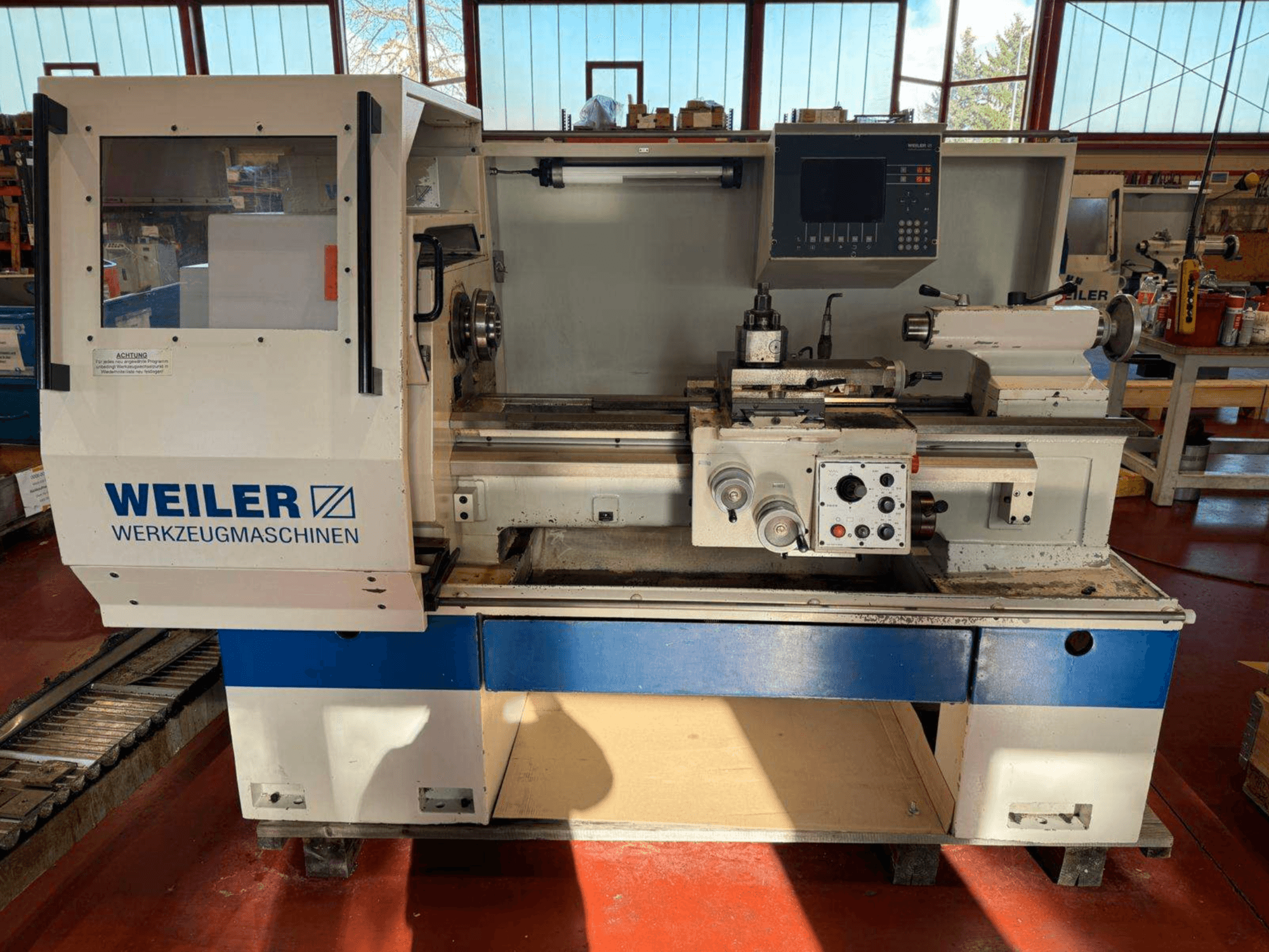 Tornio orizzontale Weiler E35 in vista frontale, con pannello di controllo e componenti del tornio.