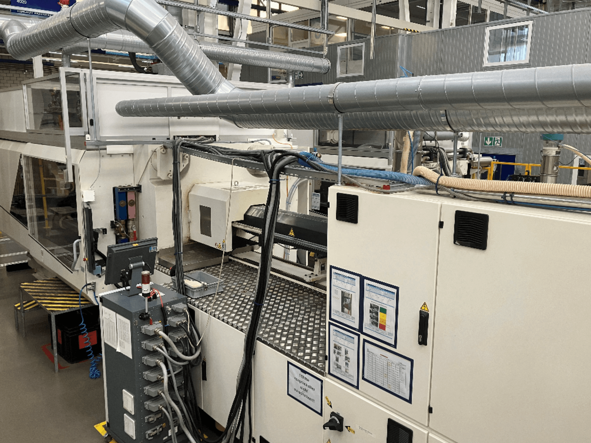 Macchinari industriali con tubazioni, pannelli di controllo e manuali operativi completi, visti da una prospettiva dall'alto verso il basso.