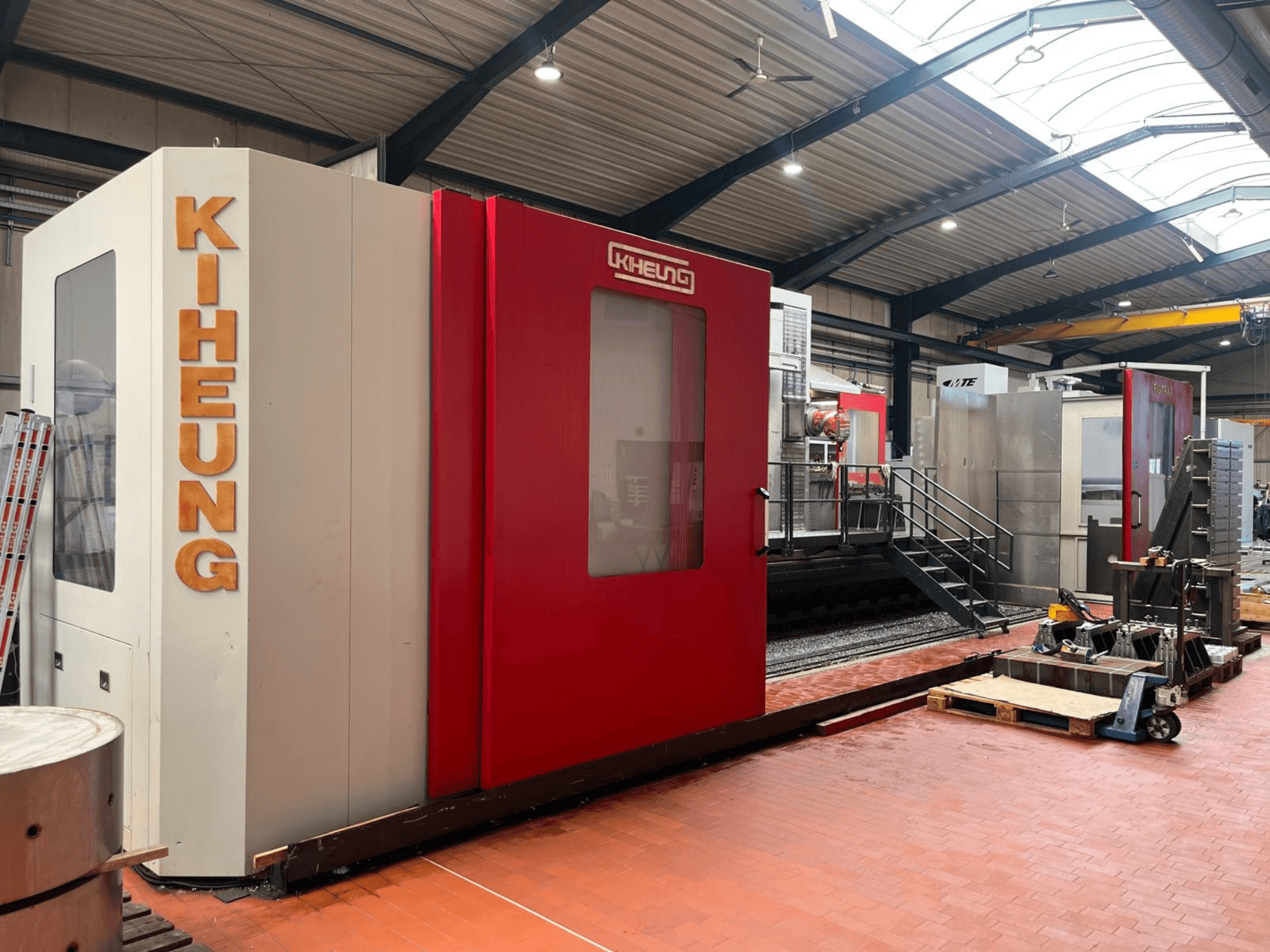 Fresatrice a bancale KIHEUNG RIGITRAX X 8000 in un'officina, vista frontale con carenatura rossa e bianca.