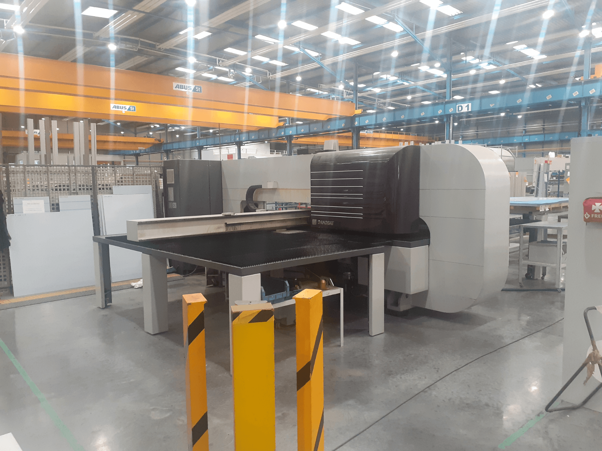 Rettificatrice cilindrica DANOBAT CHROMA 30 in officina, vista laterale con grande tavolo e barriere di sicurezza in primo piano.