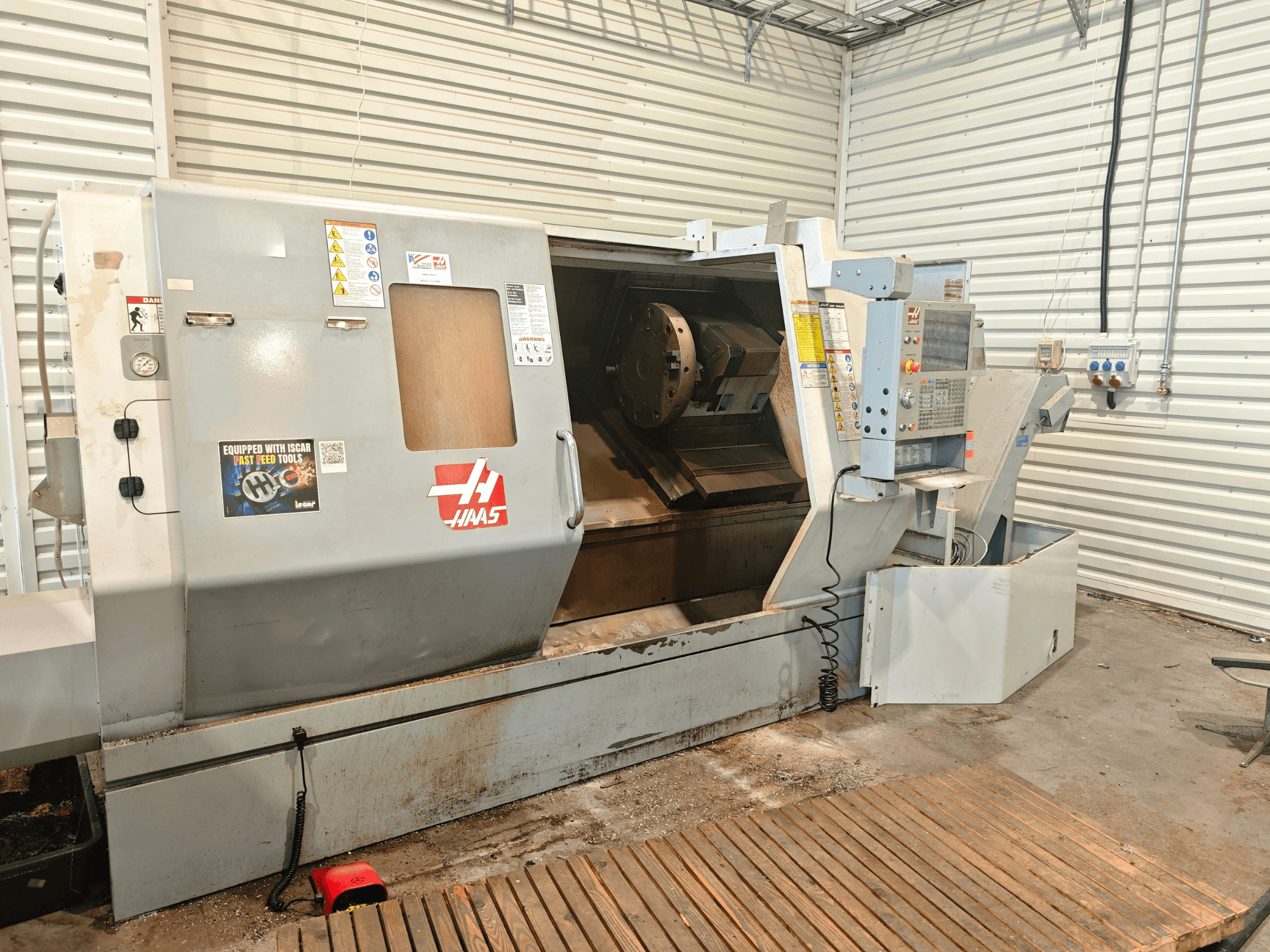 Tornio orizzontale Haas SL-40HE, vista frontale, con pannello di controllo, area di lavoro ed etichette di sicurezza.