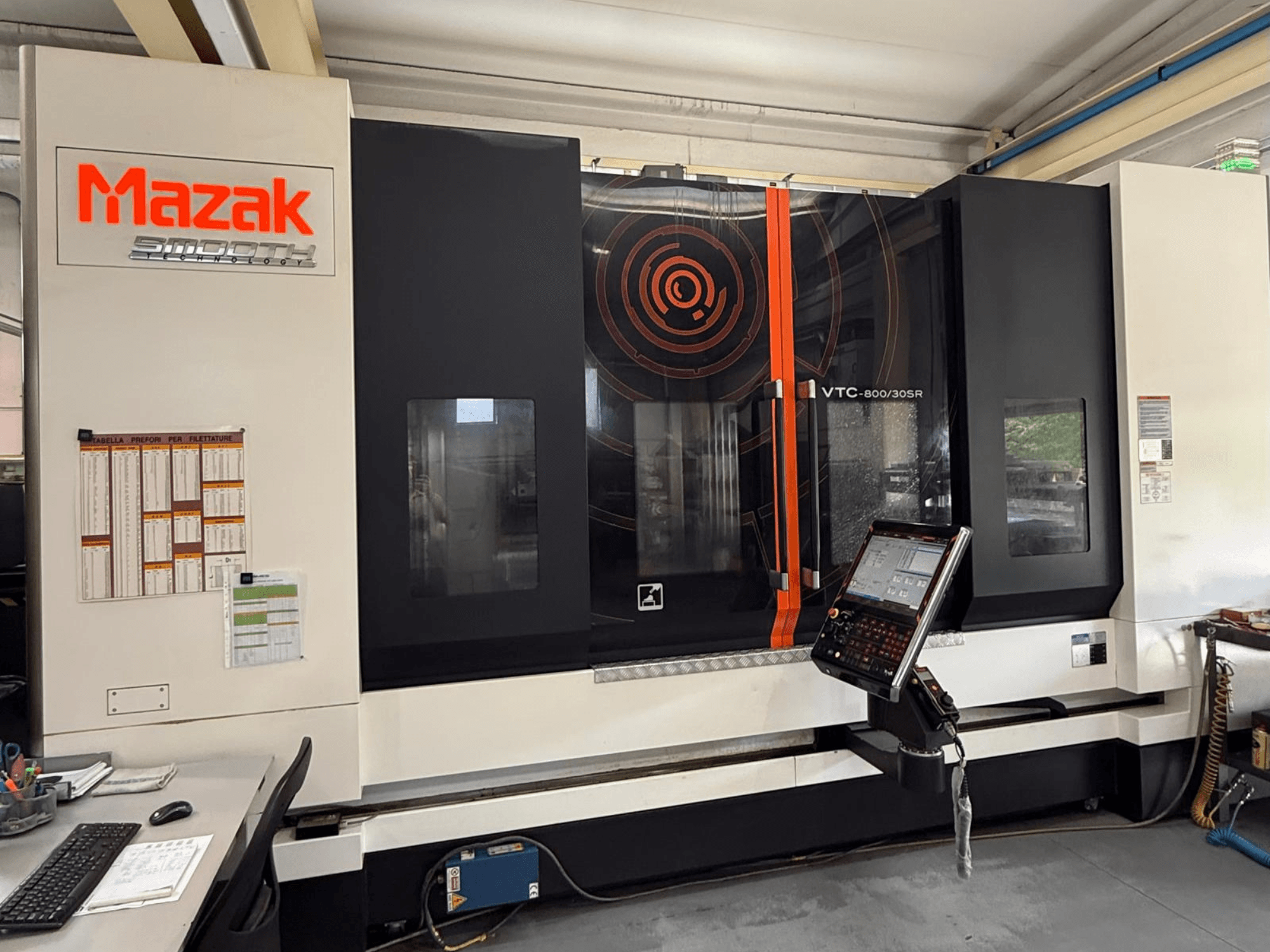 Centro di lavorazione verticale Mazak VTC-800/30SR, vista frontale che mostra il pannello di controllo, il display e l'area di lavoro.
