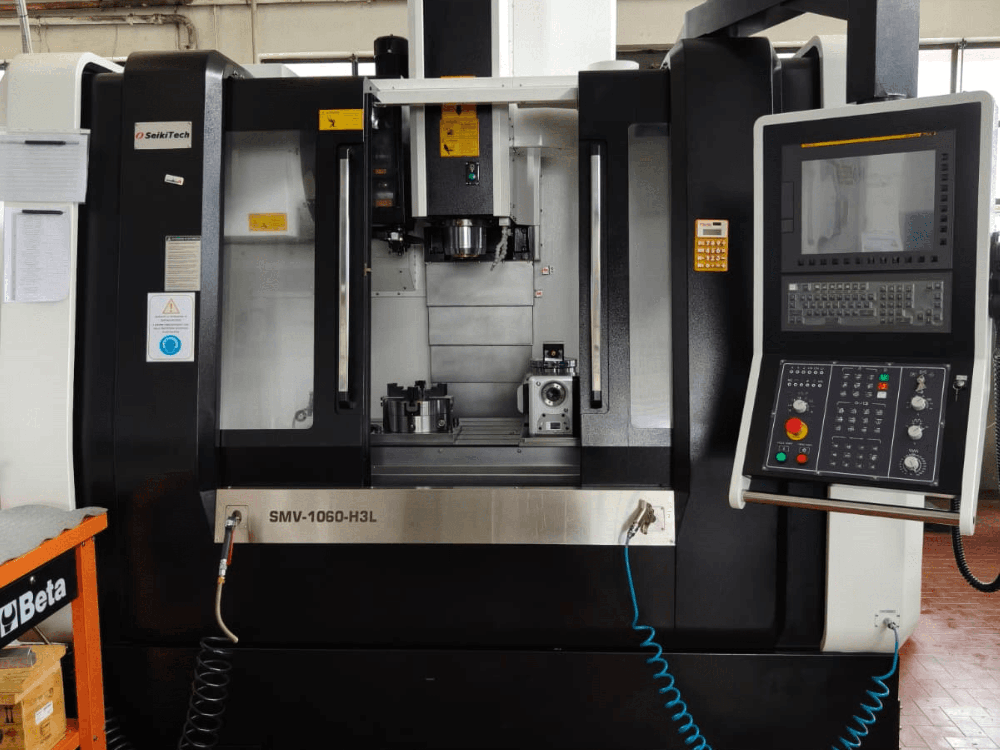 Centro di lavoro verticale Finetech SMV 1060 H3L, vista frontale che mostra comandi, mandrino e pezzi nell'area di lavorazione.