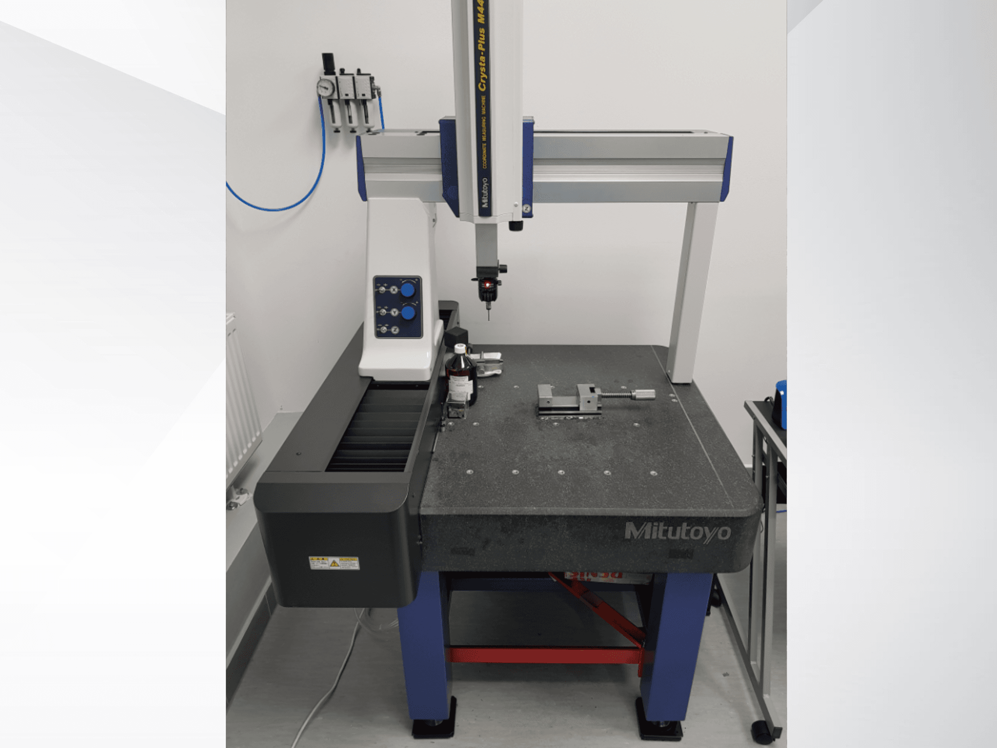 CMM Mitutoyo Crysta-Plus M443 vista frontale, con sonda di misura, pannello di controllo e tavola di ispezione con dispositivi di fissaggio.