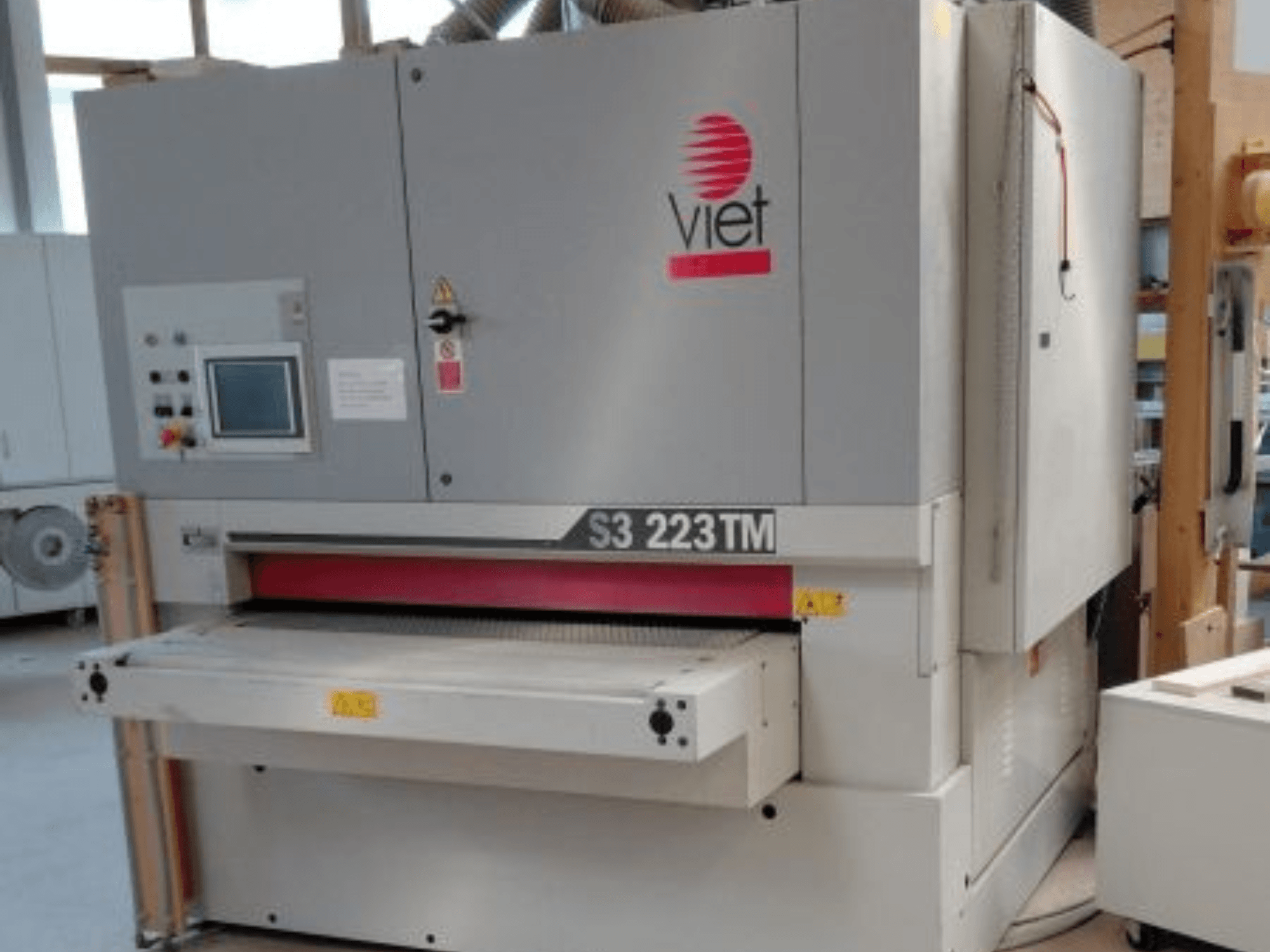 Levigatrice a nastro VIET S3 223TM vista frontale, con pannello di controllo, piano di levigatura ed etichette di sicurezza.