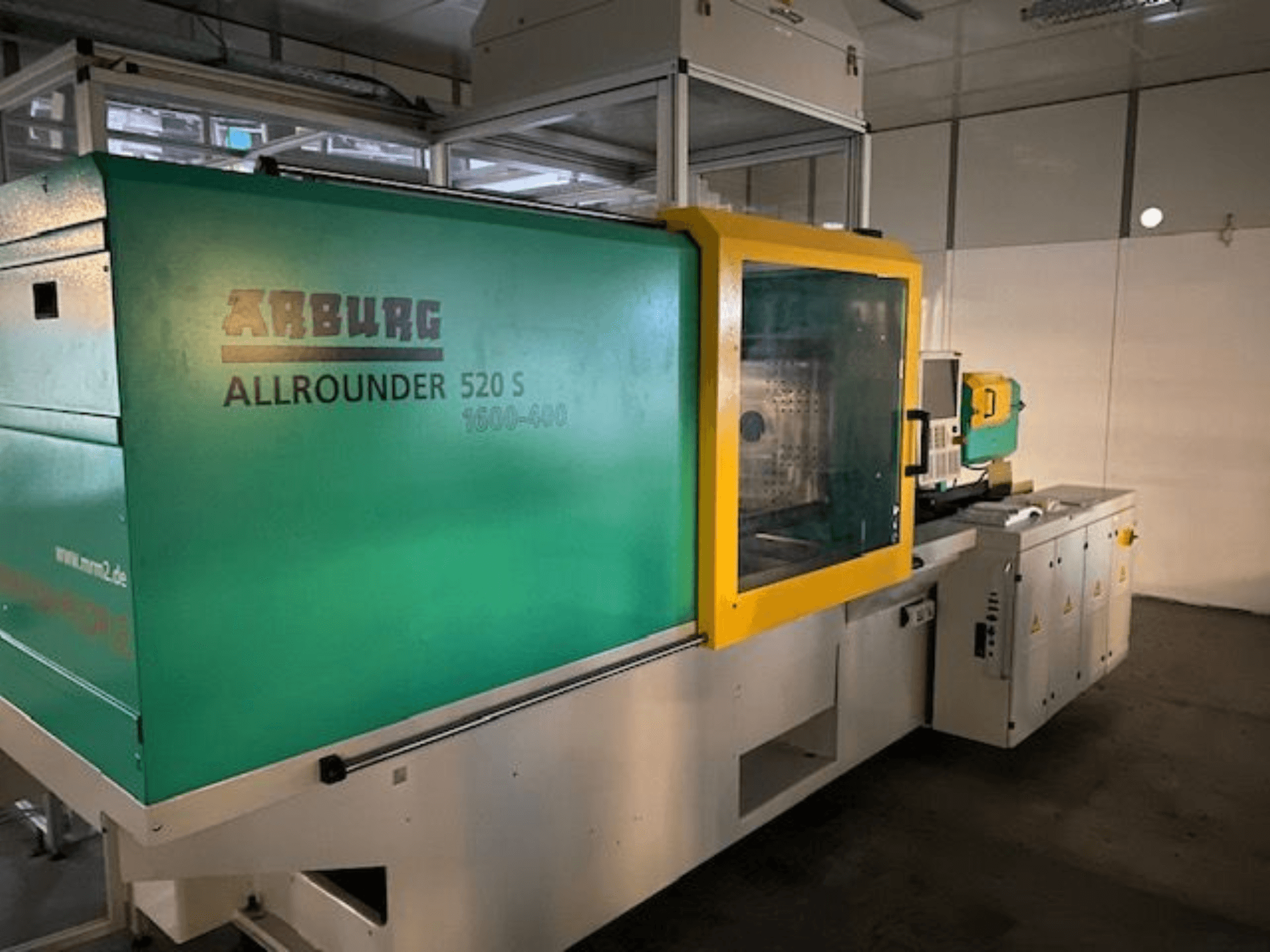 Macchina ad iniezione Arburg Allrounder 520 S, vista laterale, con esterno verde e giallo, dettagli tecnici visibili.