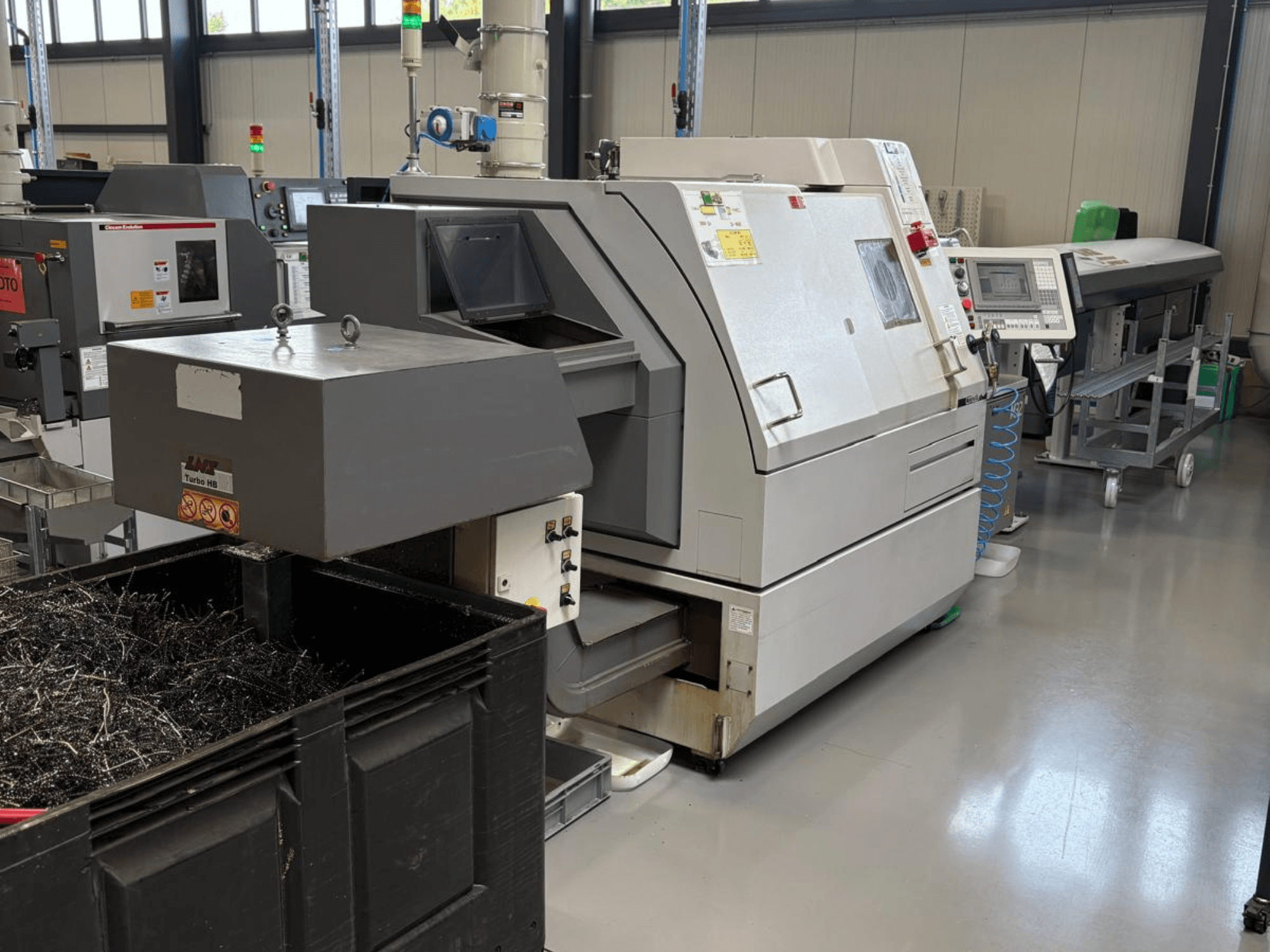 Macchina industriale LTA Turbo H8, vista laterale, con un grande contenitore per i trucioli metallici e il pannello di controllo in un ambiente industriale.