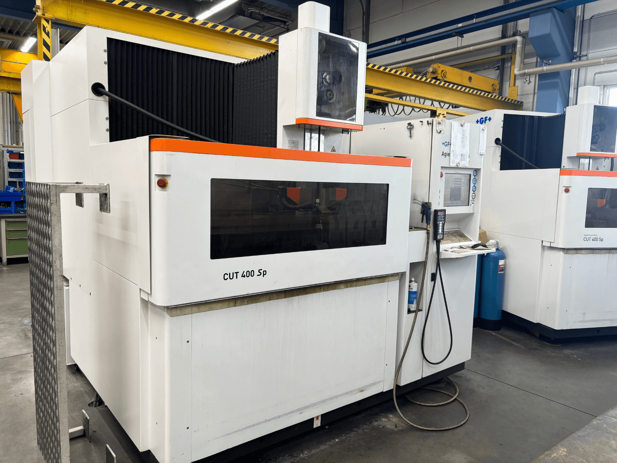 Macchina per elettroerosione a filo +GF+ AGIECHARMILLES CUT 400 Sp, vista frontale, con pannello di controllo e sistema di raffreddamento integrato.