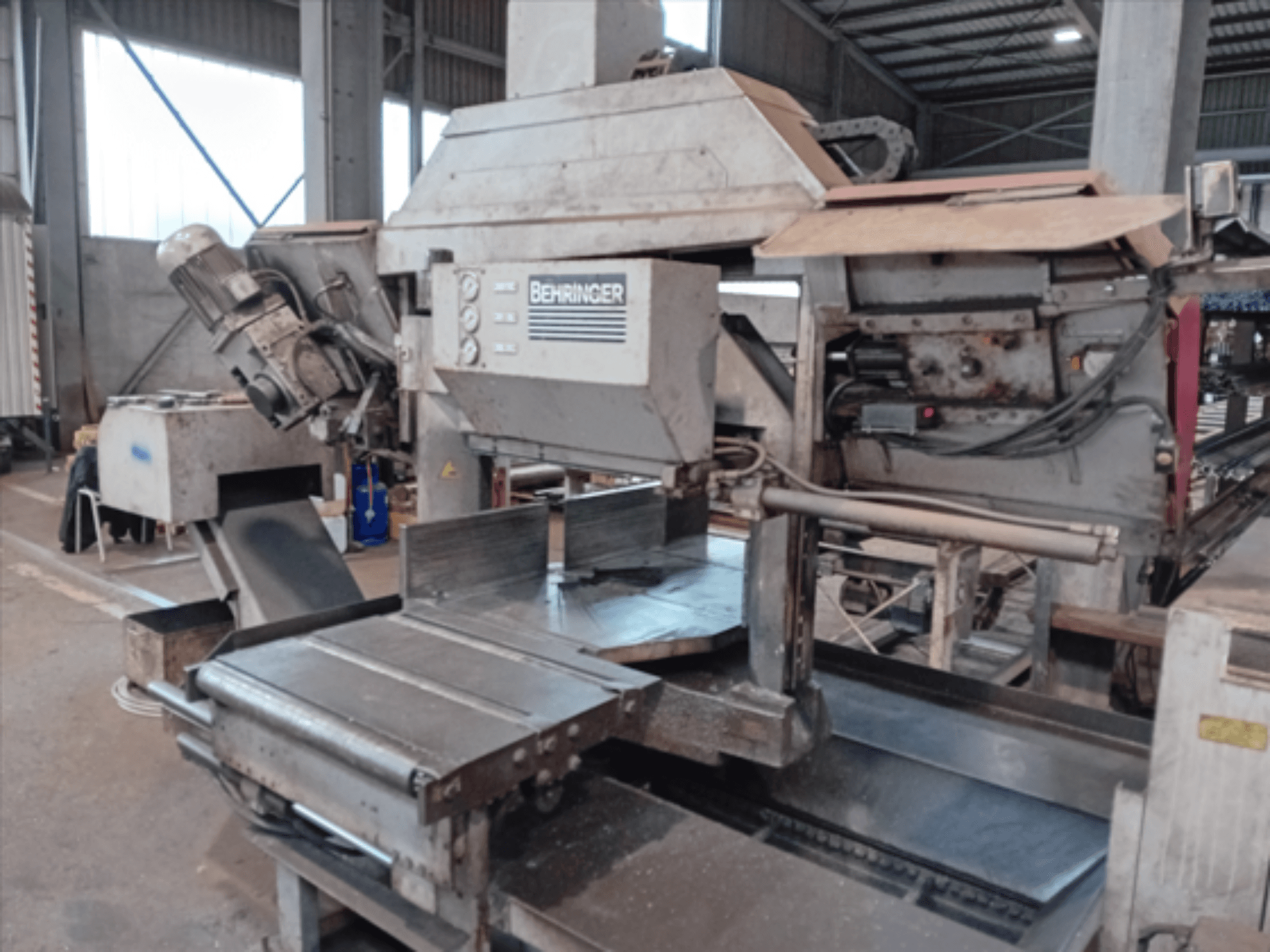 Sega a nastro Behringer, vista frontale, con lama grande, motore e tavolo regolabile, ideale per il taglio dei metalli in officina.