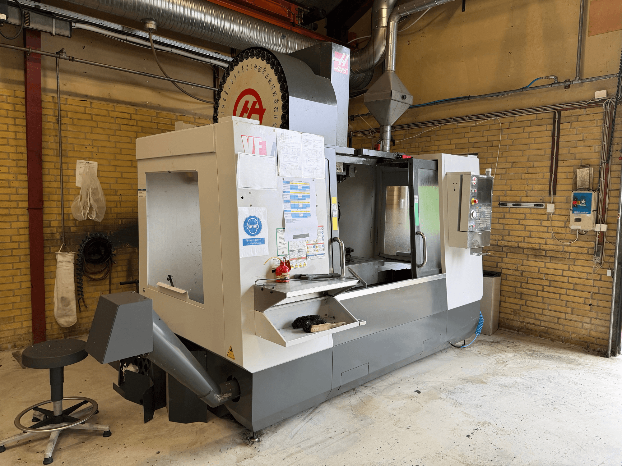 Centro di lavorazione verticale HAAS VF-4, vista frontale; in primo piano si vedono il pannello di controllo e il portautensili, mentre sullo sfondo è visibile l'allestimento di produzione.