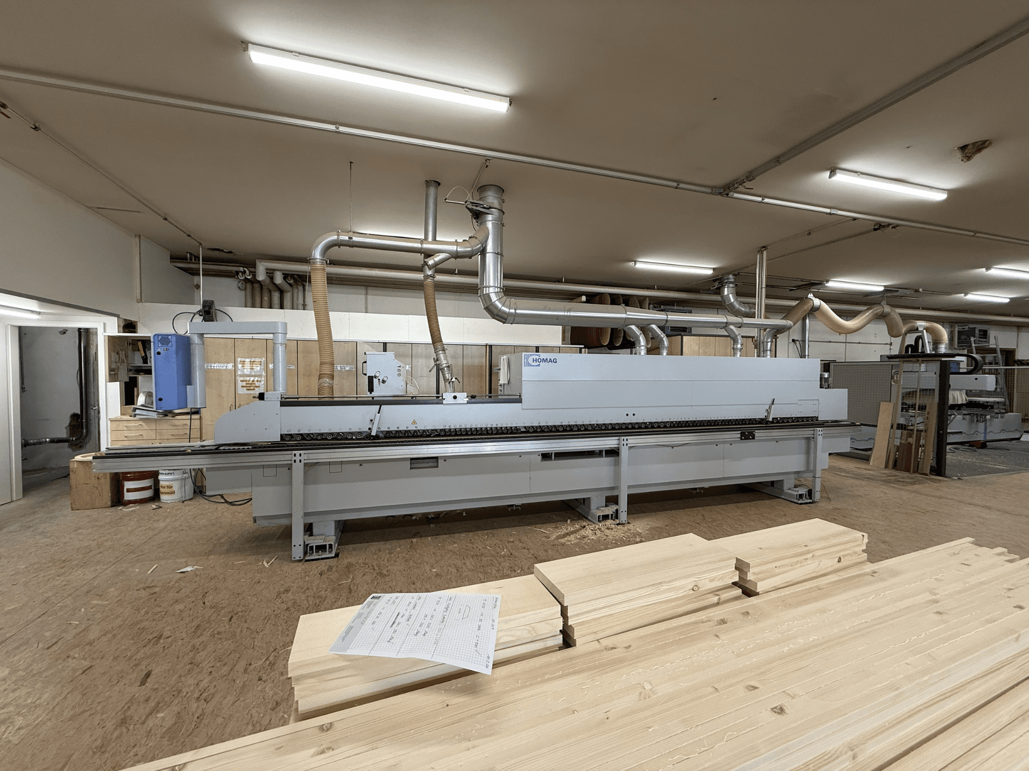 HOMAG KAL211 Bordatrice in officina, vista frontale, con tavole di legno e macchinari in un ambiente ben illuminato.