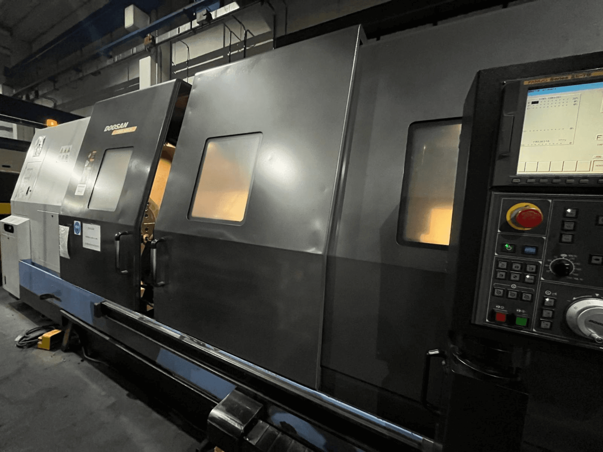 Tornio CNC Doosan in vista frontale, con pannello di controllo e interfaccia operatore con display digitale e pulsanti visibili.