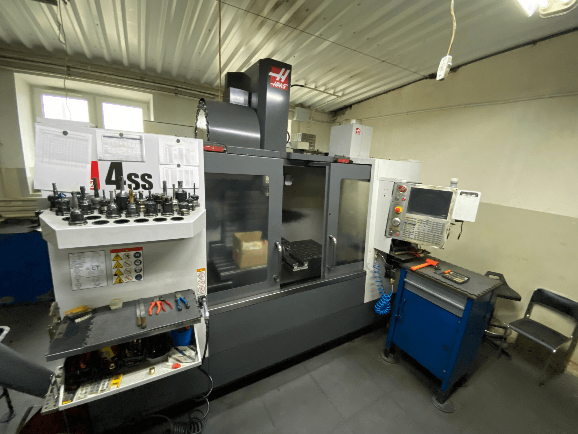 Centro di lavoro verticale Haas VF-4SS, vista frontale con portautensili e pannello di controllo. Sono visibili gli utensili in uso e l'area di lavoro.