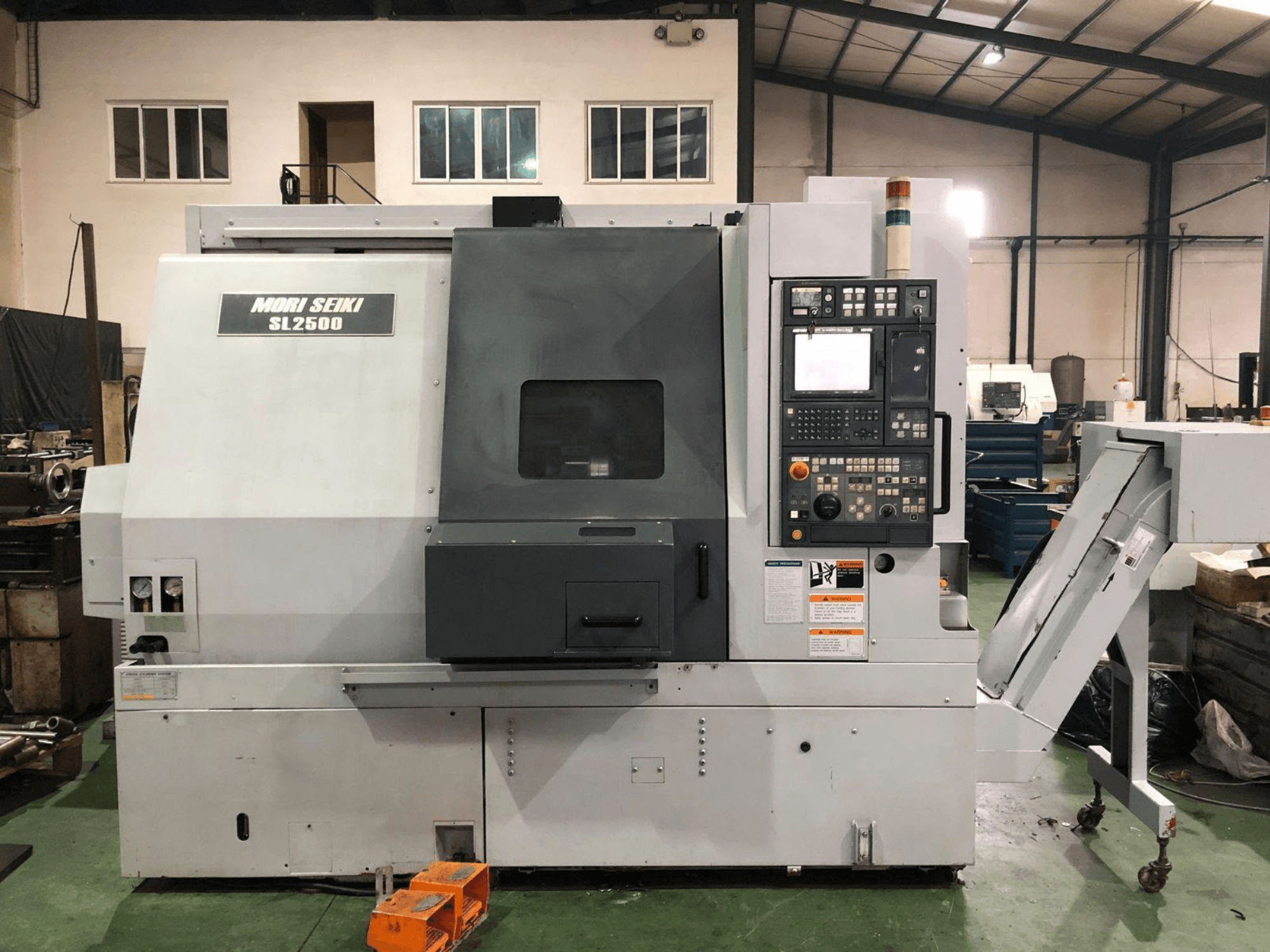 Centro di fresatura e tornitura DMG Mori Seiki SL 2500 Y, vista laterale con pannello di controllo e trasportatore dei trucioli visibili.