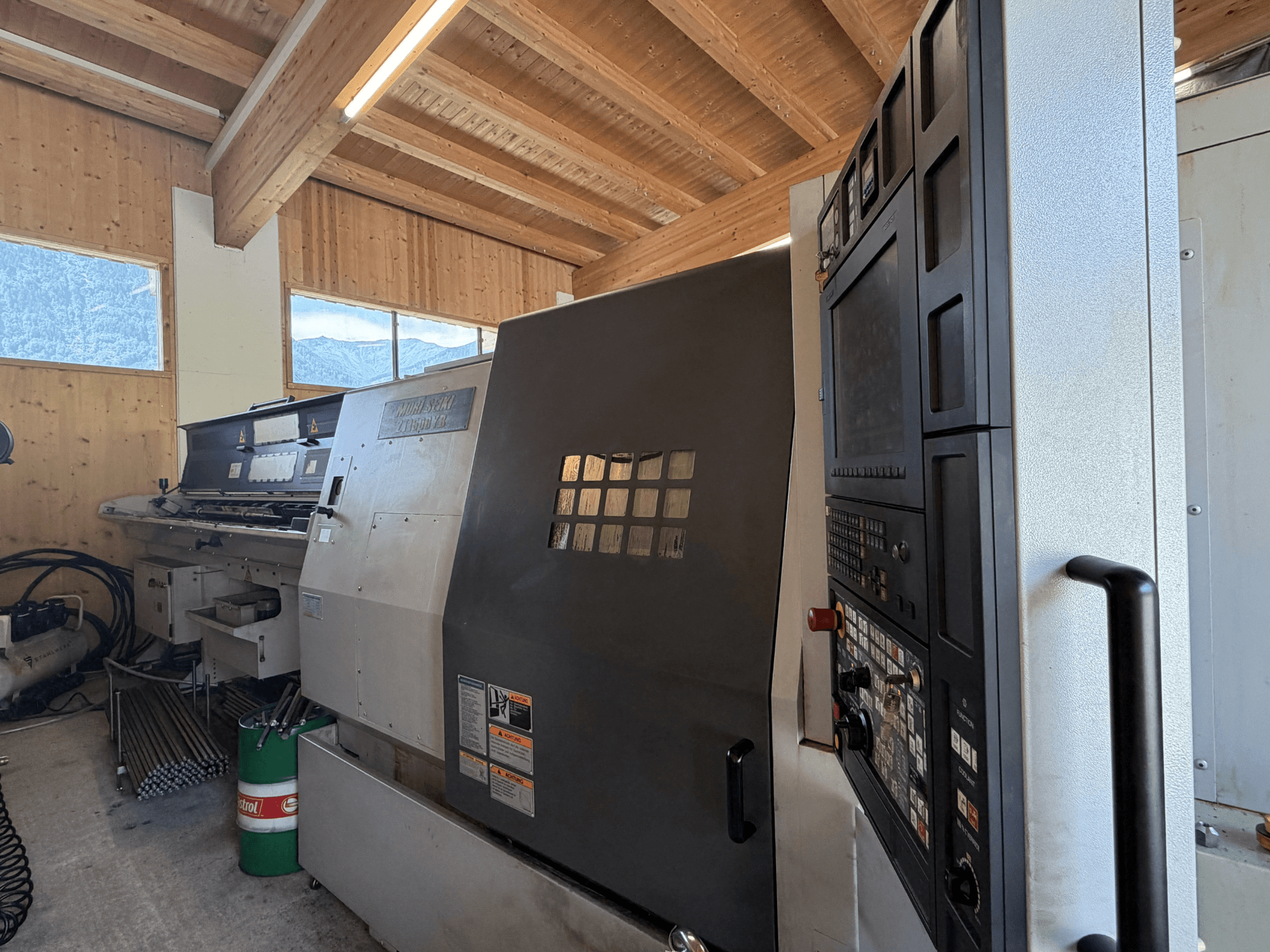 Centro di tornitura e fresatura MORI SEIKI ZT1500YB in un'officina; vista laterale che mostra il pannello di controllo e le caratteristiche della macchina.