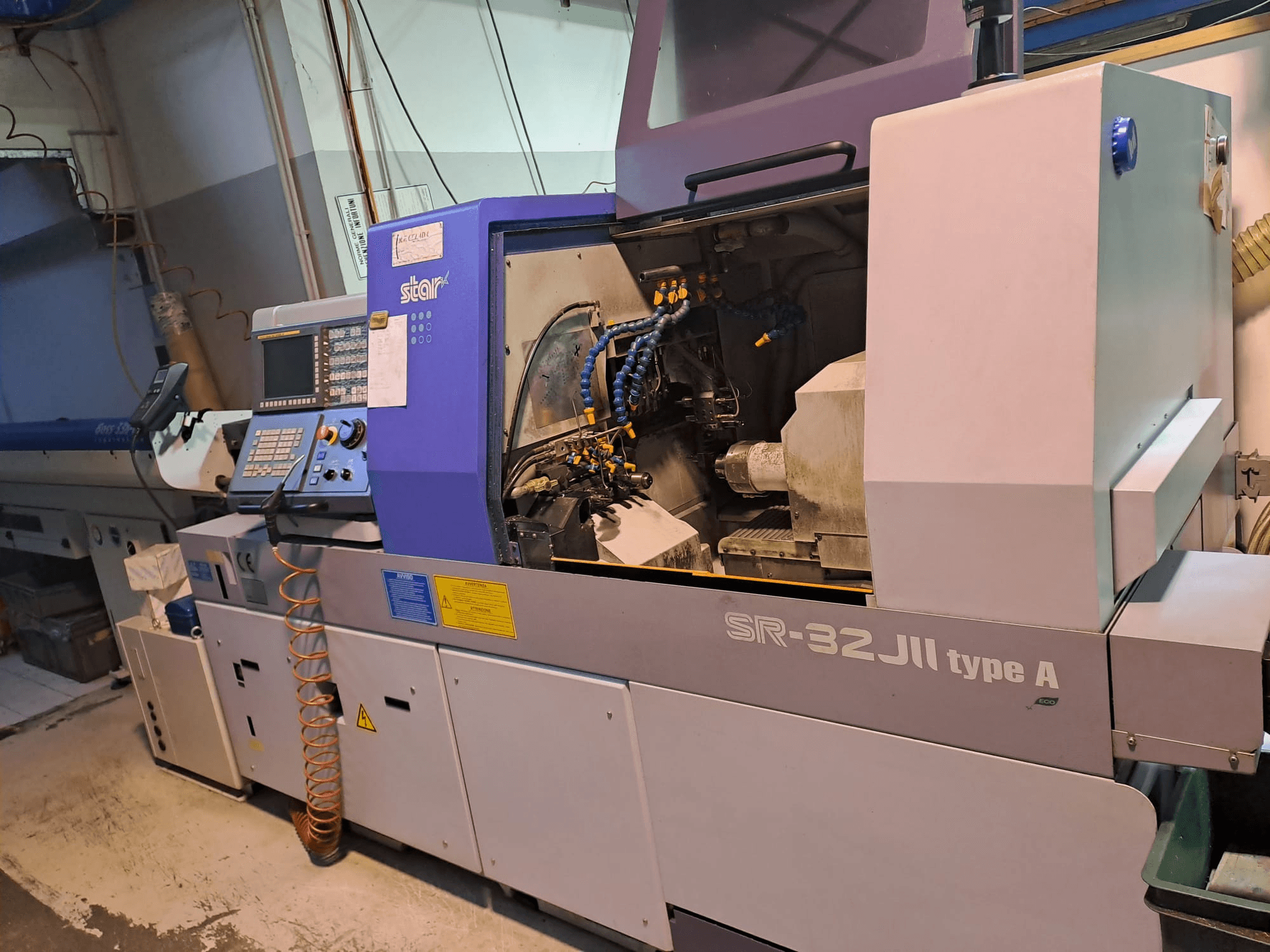 STAR MICRONICS SR-32JII-typeA Tornio di tipo svizzero vista laterale, con pannello di controllo e componenti di lavorazione visibili.