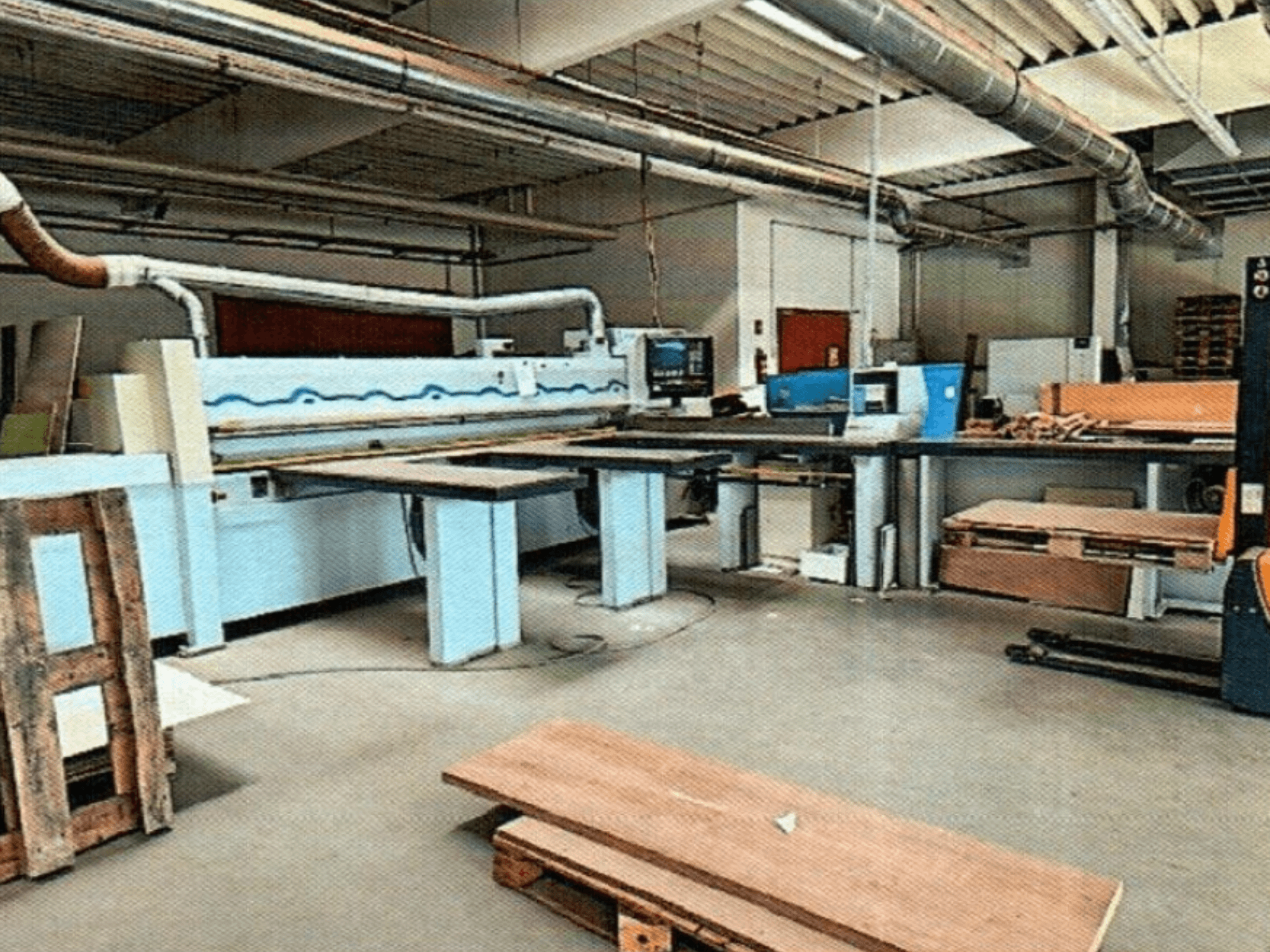 Sezionatrice HOMAG HPL 11/38/22 in un'officina, con ampio tavolo di taglio e console di visualizzazione, vista dal davanti.