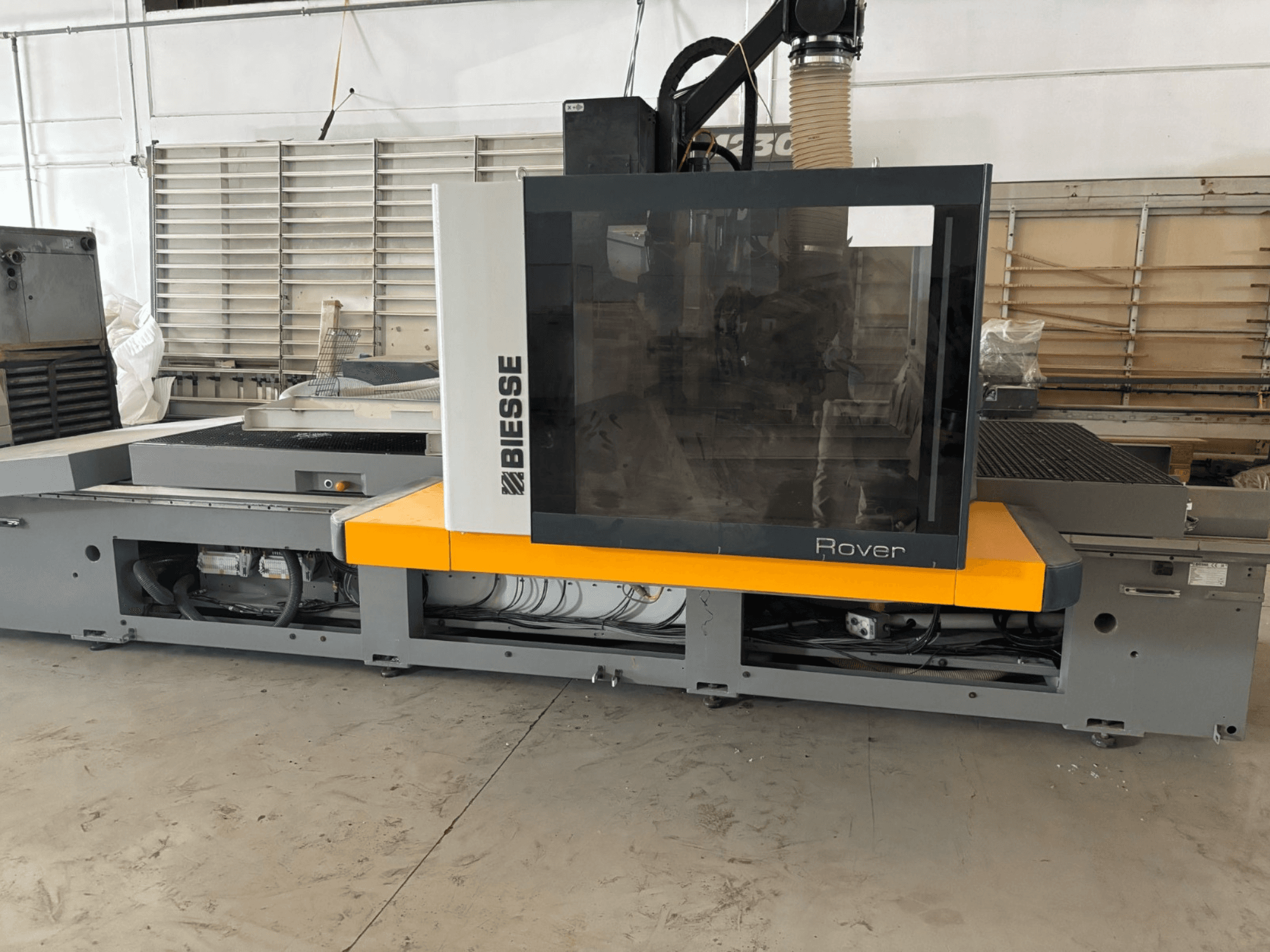 Il centro di lavoro CNC Biesse Rover, vista frontale, presenta un ampio pannello di controllo, accenti gialli e componenti meccanici a vista.