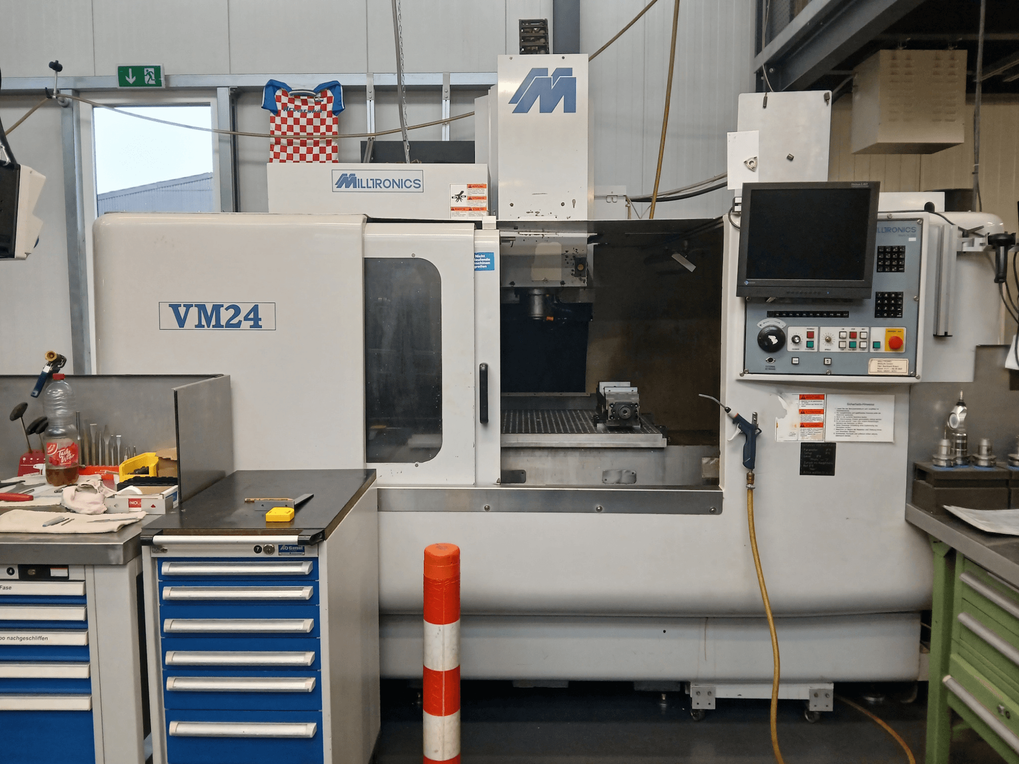 La fresatrice CNC Milltronics VM24 vista frontalmente, con il pannello di controllo, il magazzino utensili e la configurazione dell'area di lavoro.