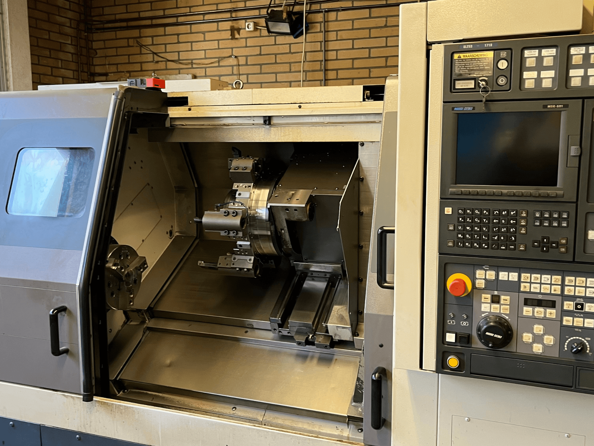 Tornio orizzontale MORI SEIKI SL-253B MC/1000, vista frontale con pannello di controllo e camera aperta con pezzi lavorati.